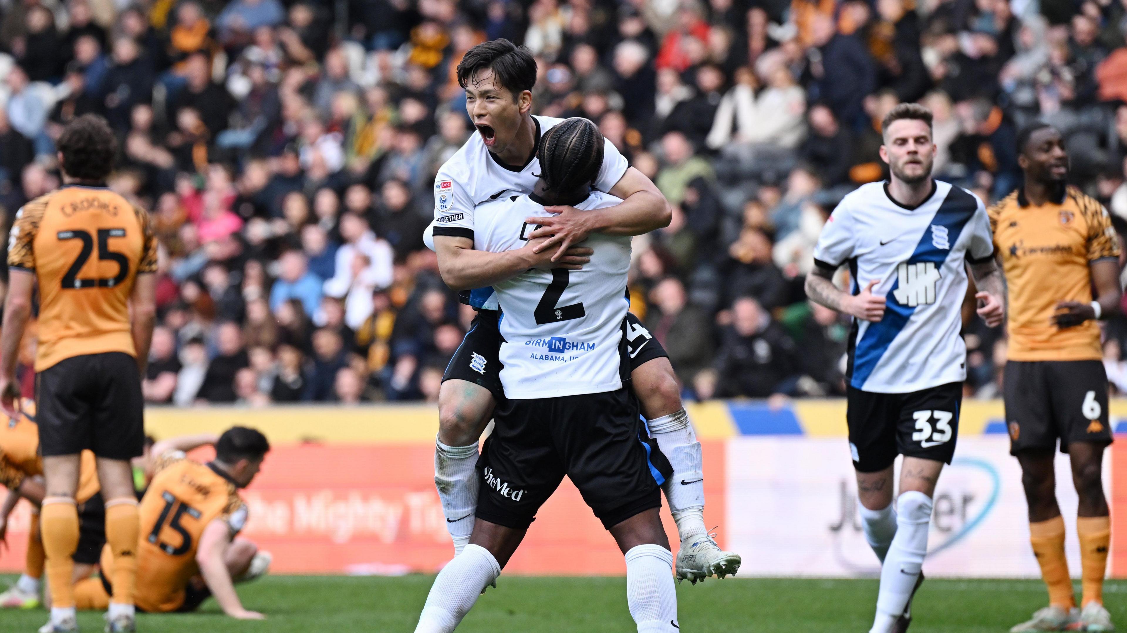 Tomoki Iwata leaps into the arms of a Birmingham team-mate