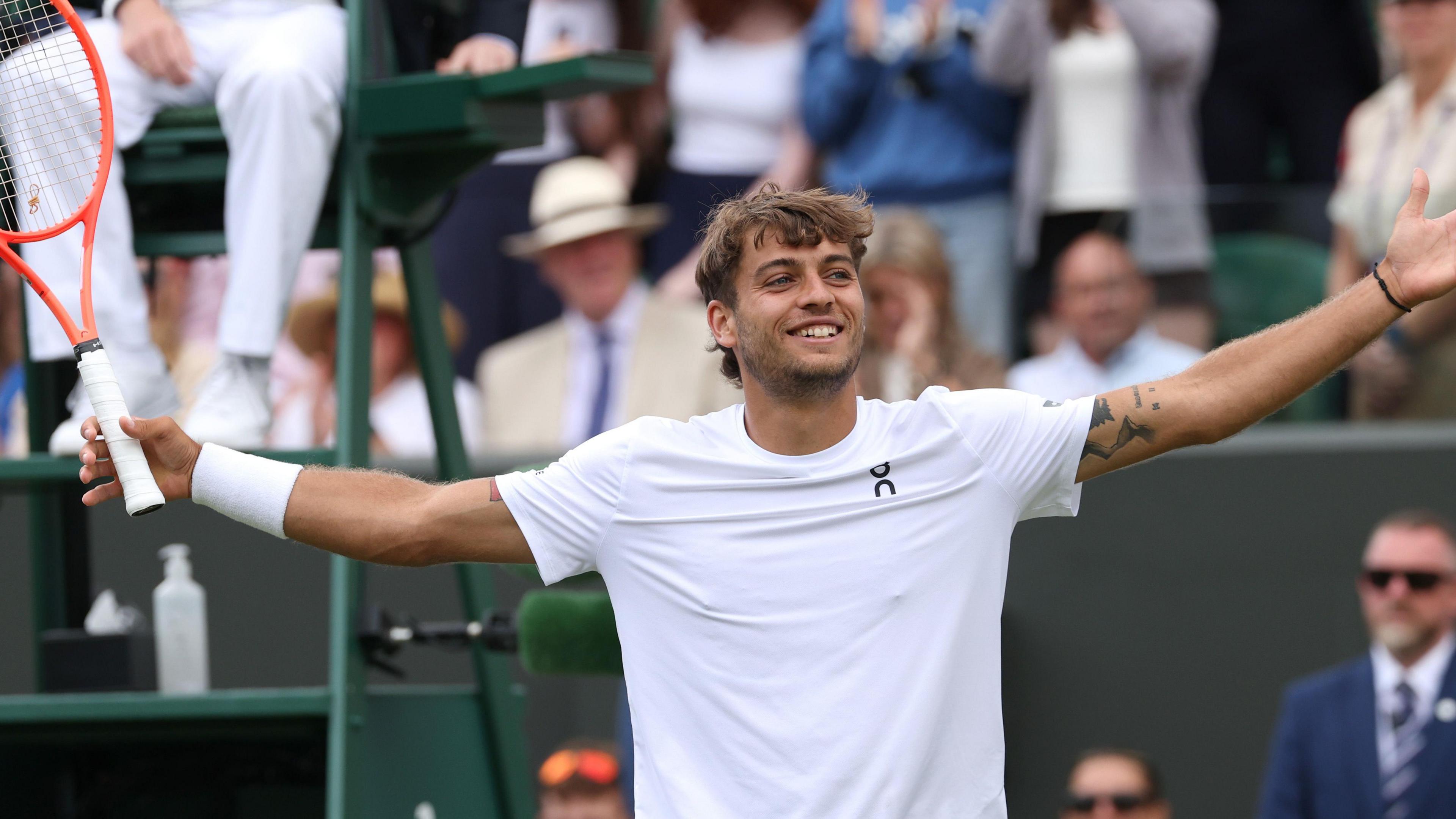Flavio Cabolli lifts arms in air to celebrate win over Marin Cilic in fourth round at Wimbledon on court two