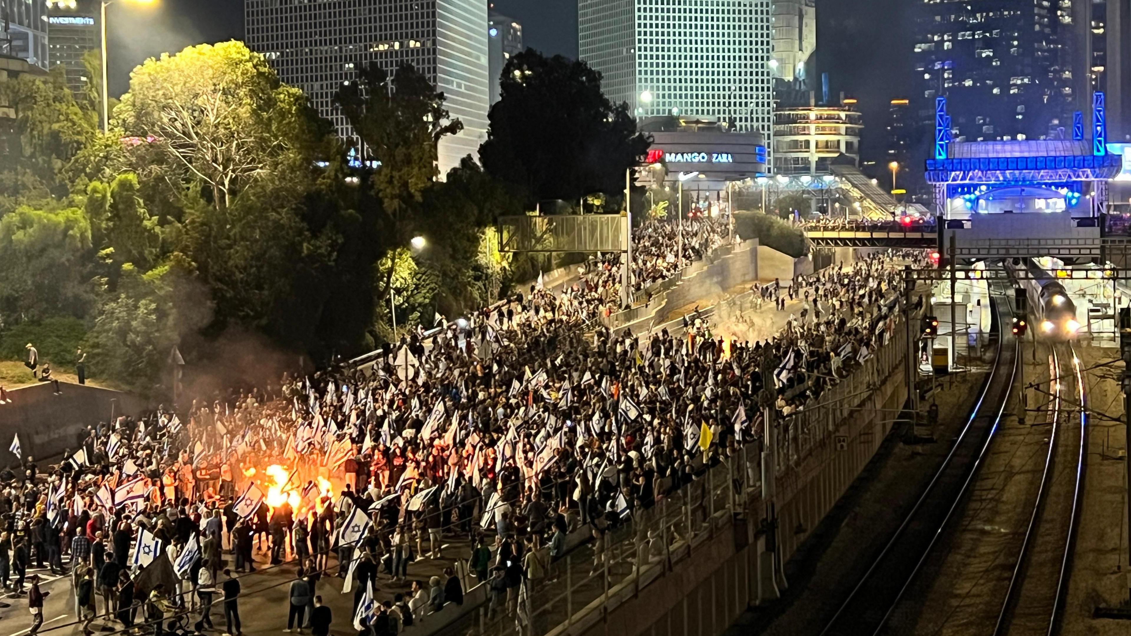 A crowd of protesters walk down the Ayalon Highway in Tel Aviv demonstrating against Gallant's dismissal on 5/11