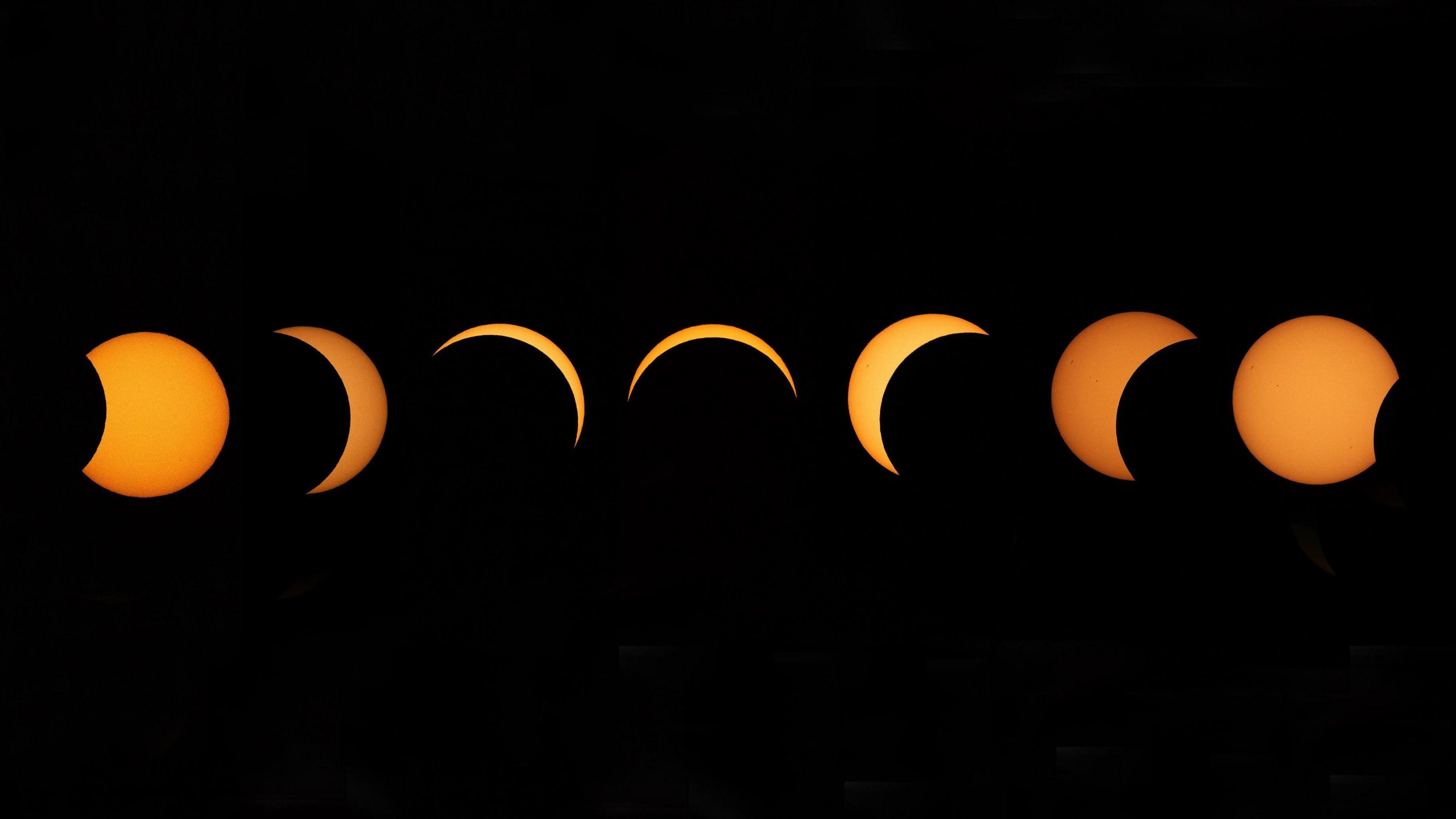 A composite image shows a sequence of the Moon passing in front of the Sun as seen from Greenwich Park in London.