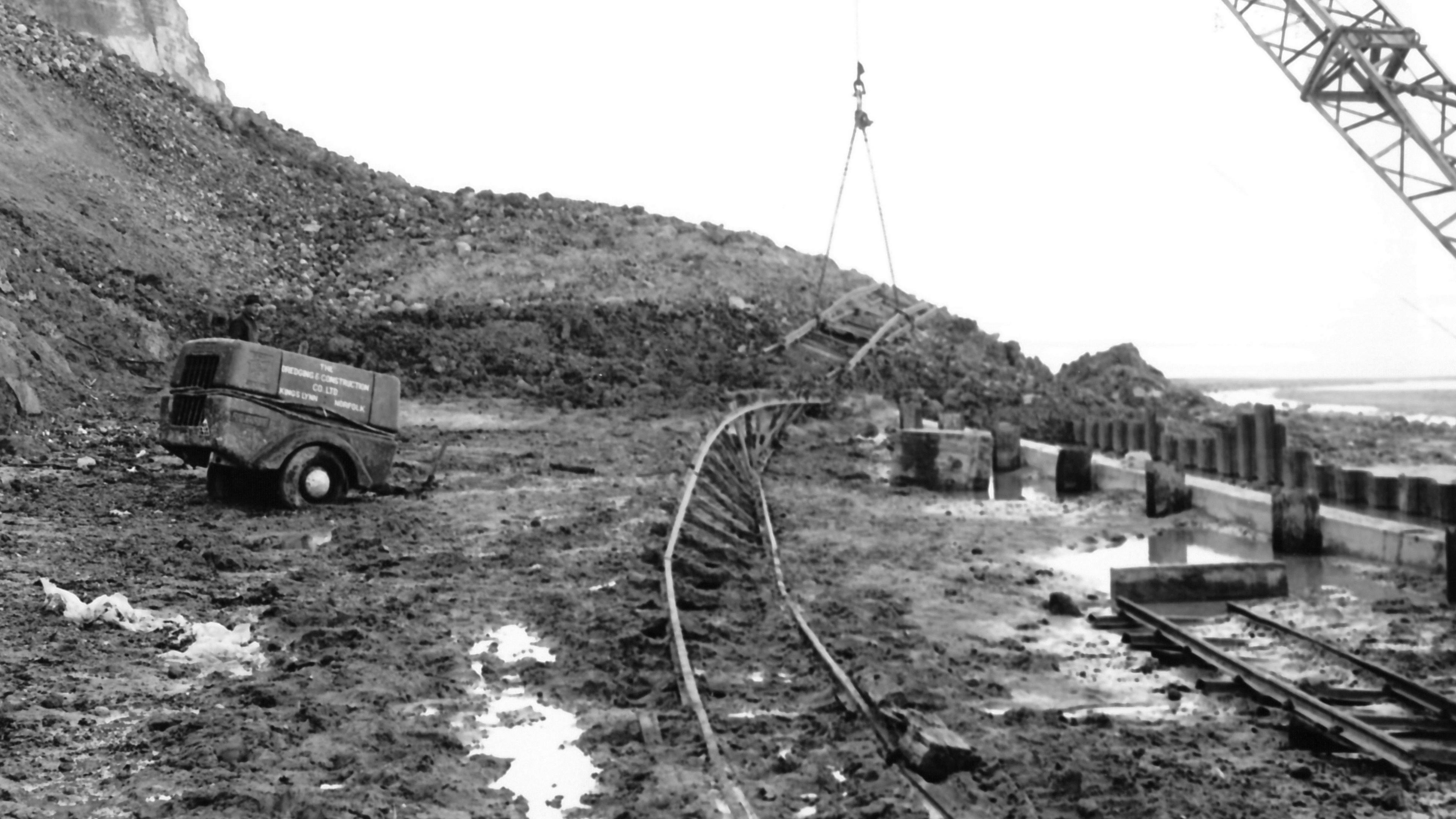 A twisted railway track which has been partly covered by a cliff fall