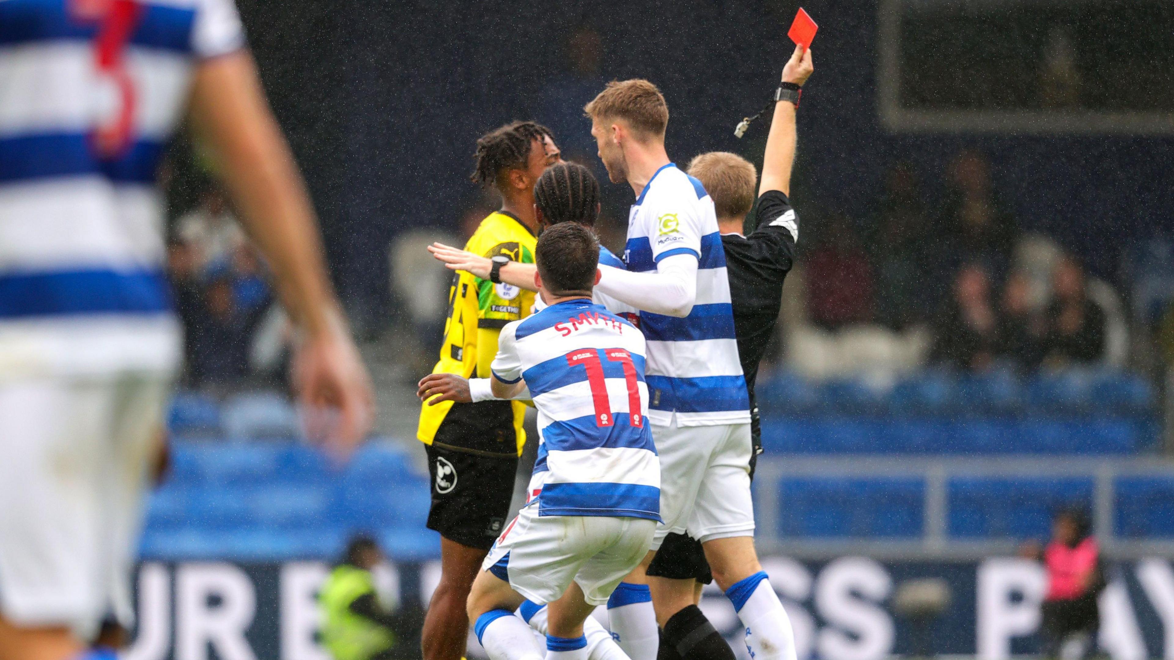 Referee Gavin Ward shows Plymouth's Freddie Issaka a red card