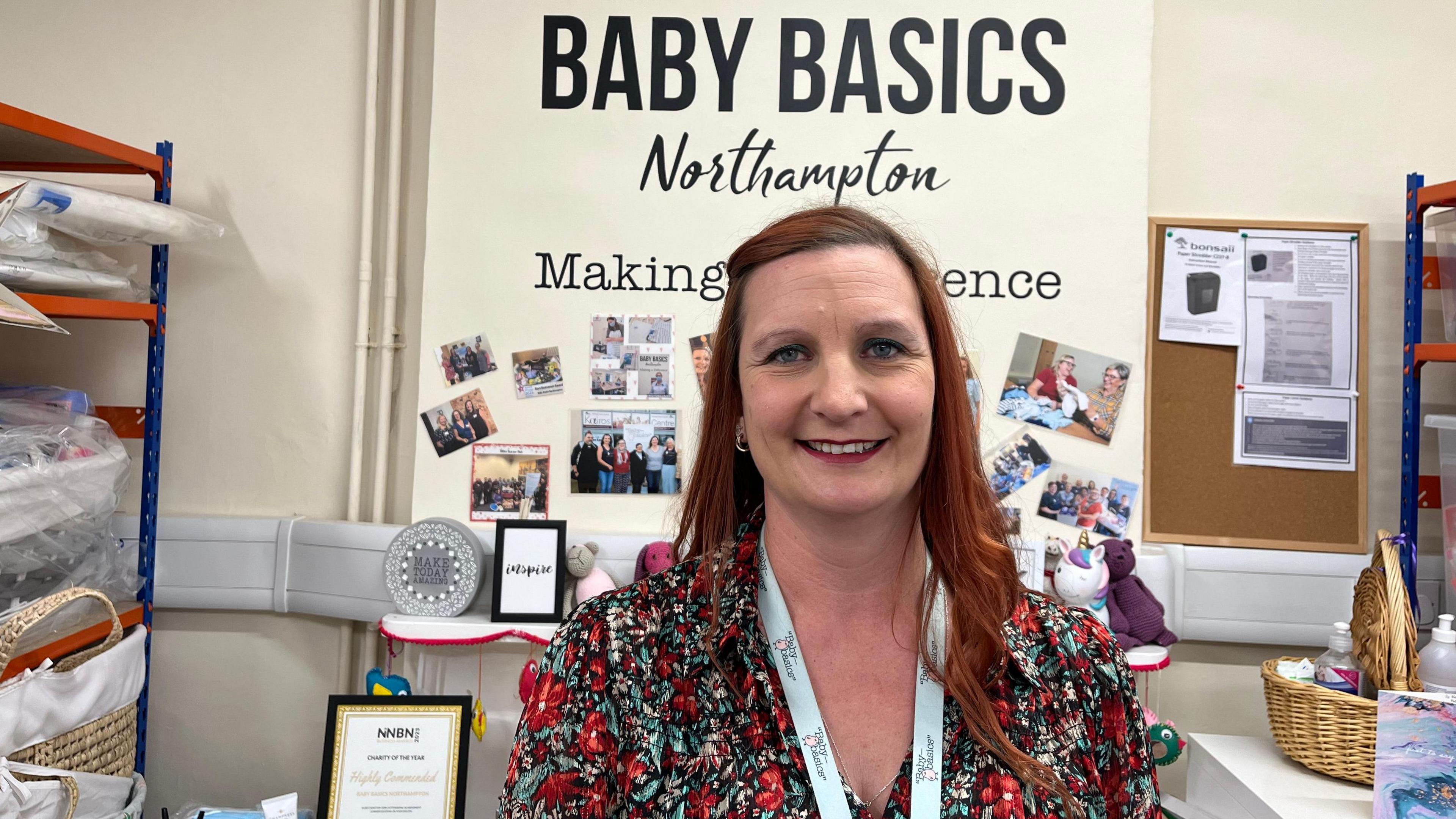 Sabrina Oakey with long auburn hair wearing a lanyard with baskets in the background