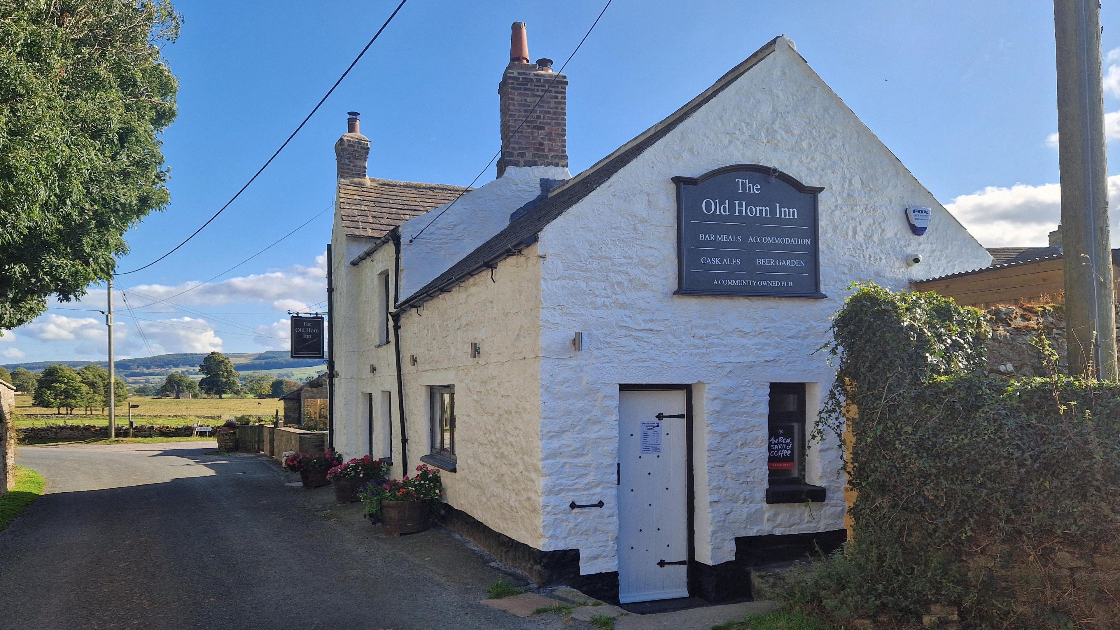 The exterior of the Old Horn Inn pub, which is painted white.