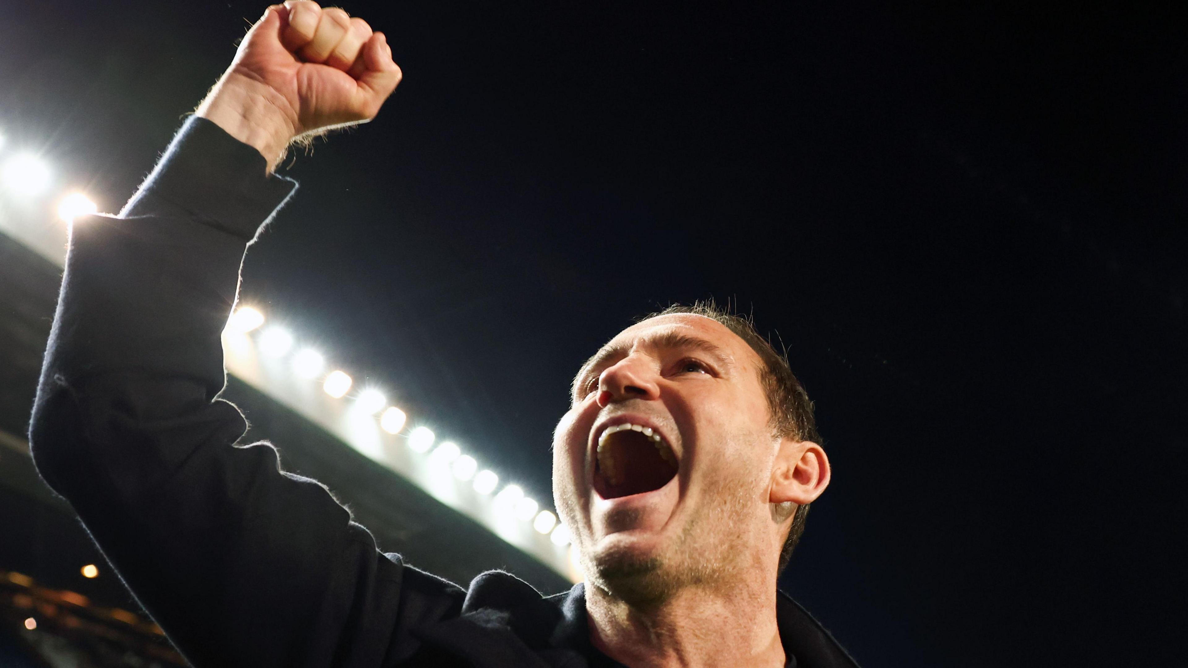 Frank Lampard raises his right fist in the air to celebrate winning promotion back to the Premier League with Coventry City after 25 years.