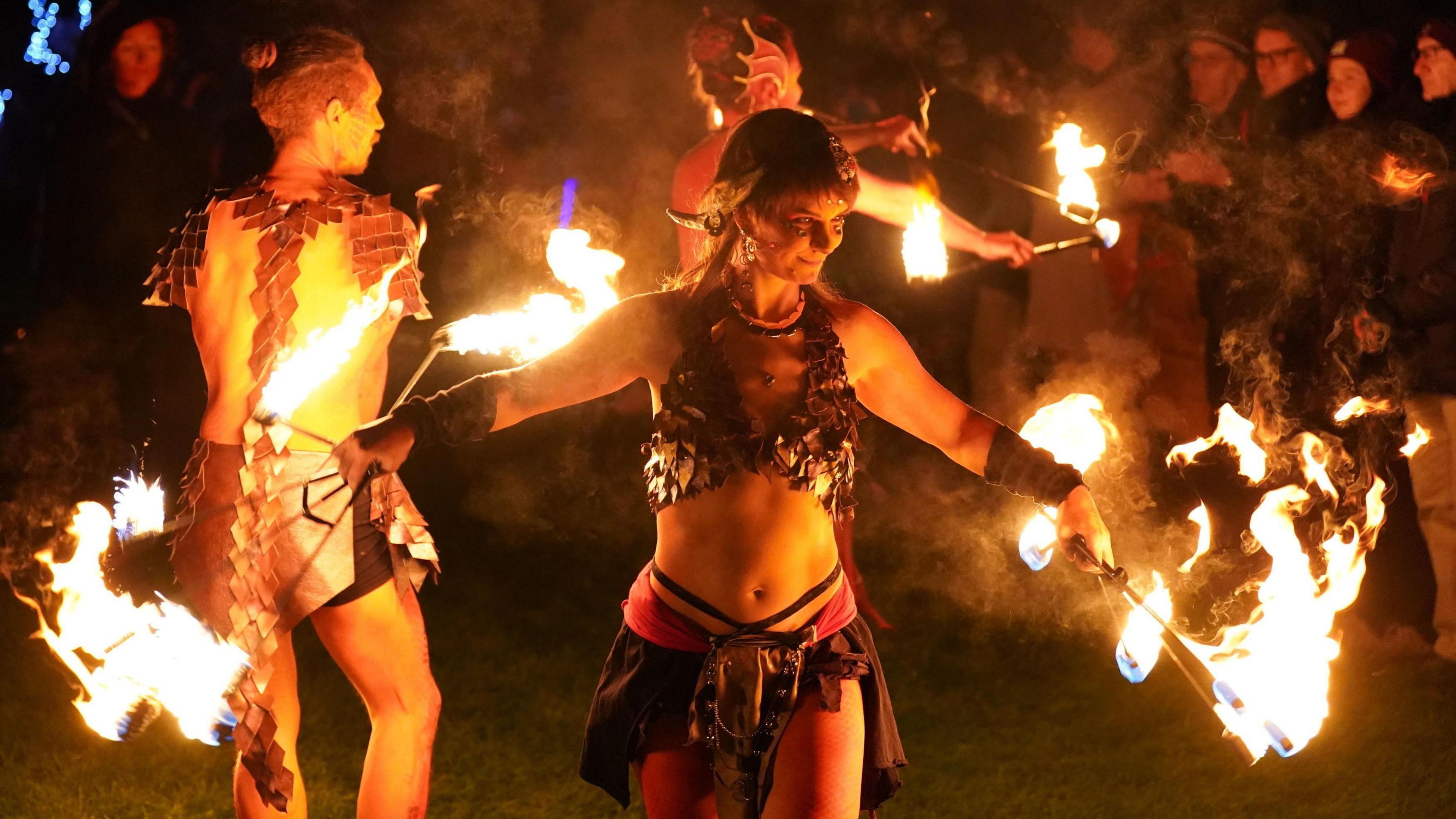 Performers twirling poles of fire