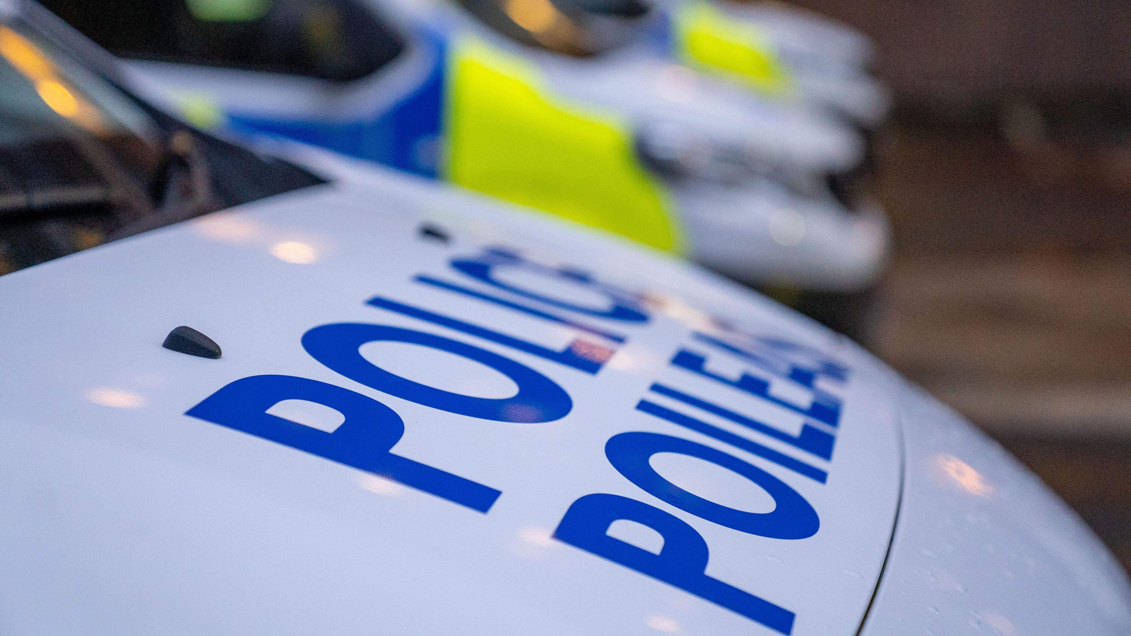A Police Scotland van parked at the side of a road. It has blue and florescent yellow markings on the side, and a large blue Police Scotland logo