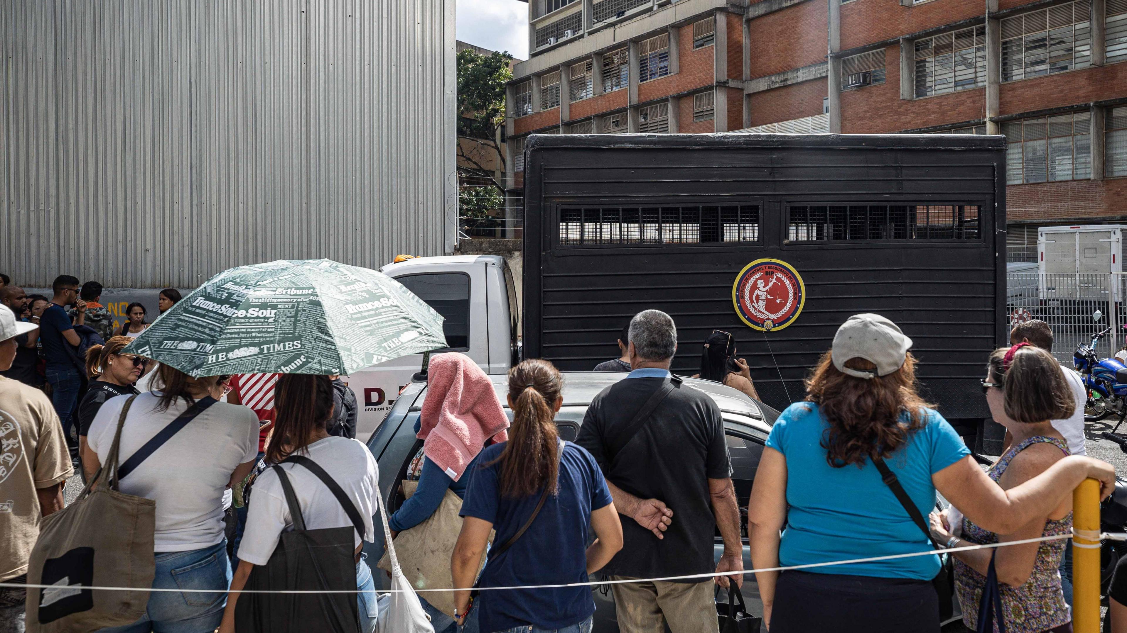 Relatives of those detained during the protests wait in line to enter the headquarters of the Bolivarian National Police in Caracas