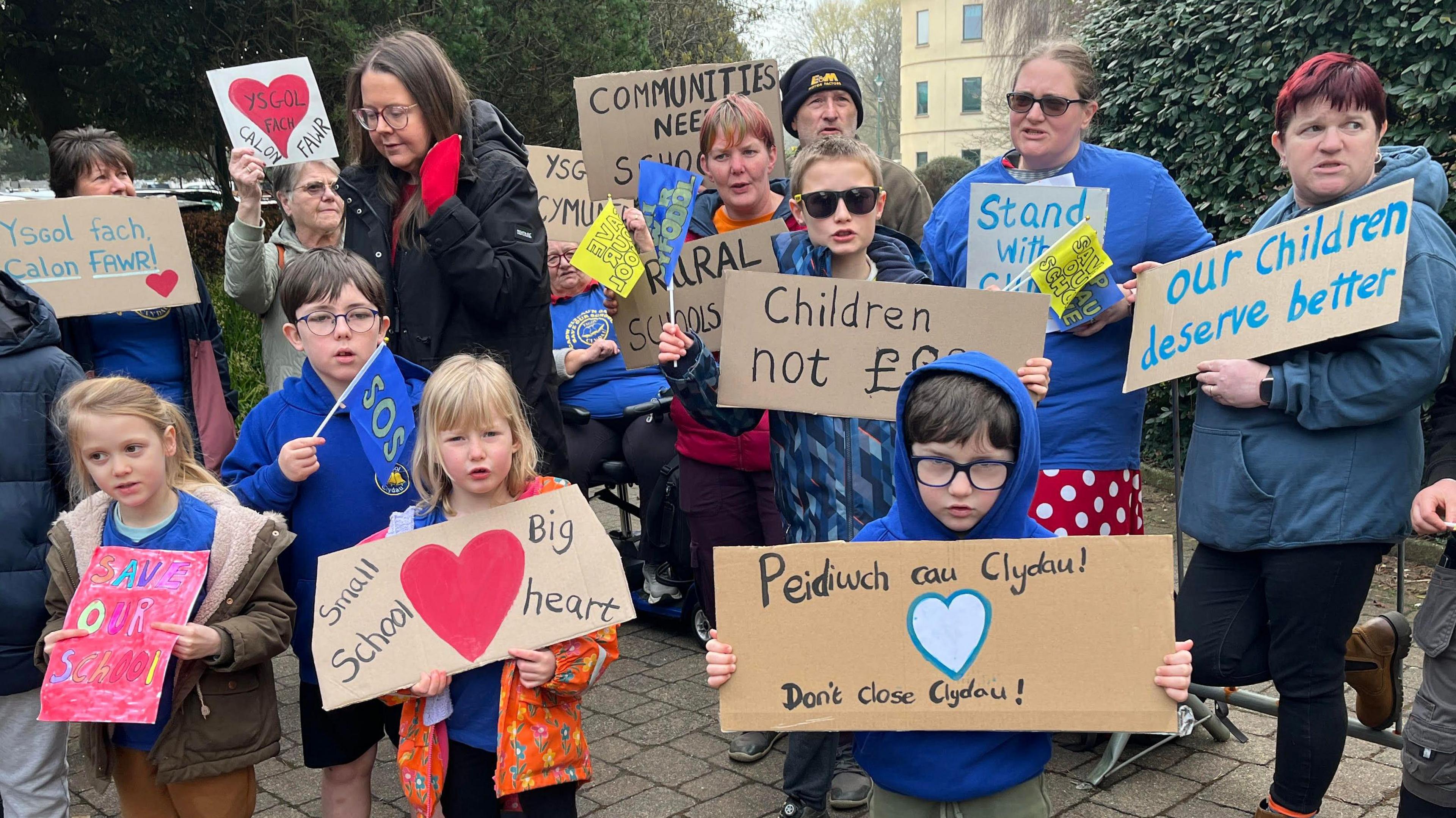 Rhieni a phlant yn dal arwyddion o blaid cadw Ysgol Clydau ar agor