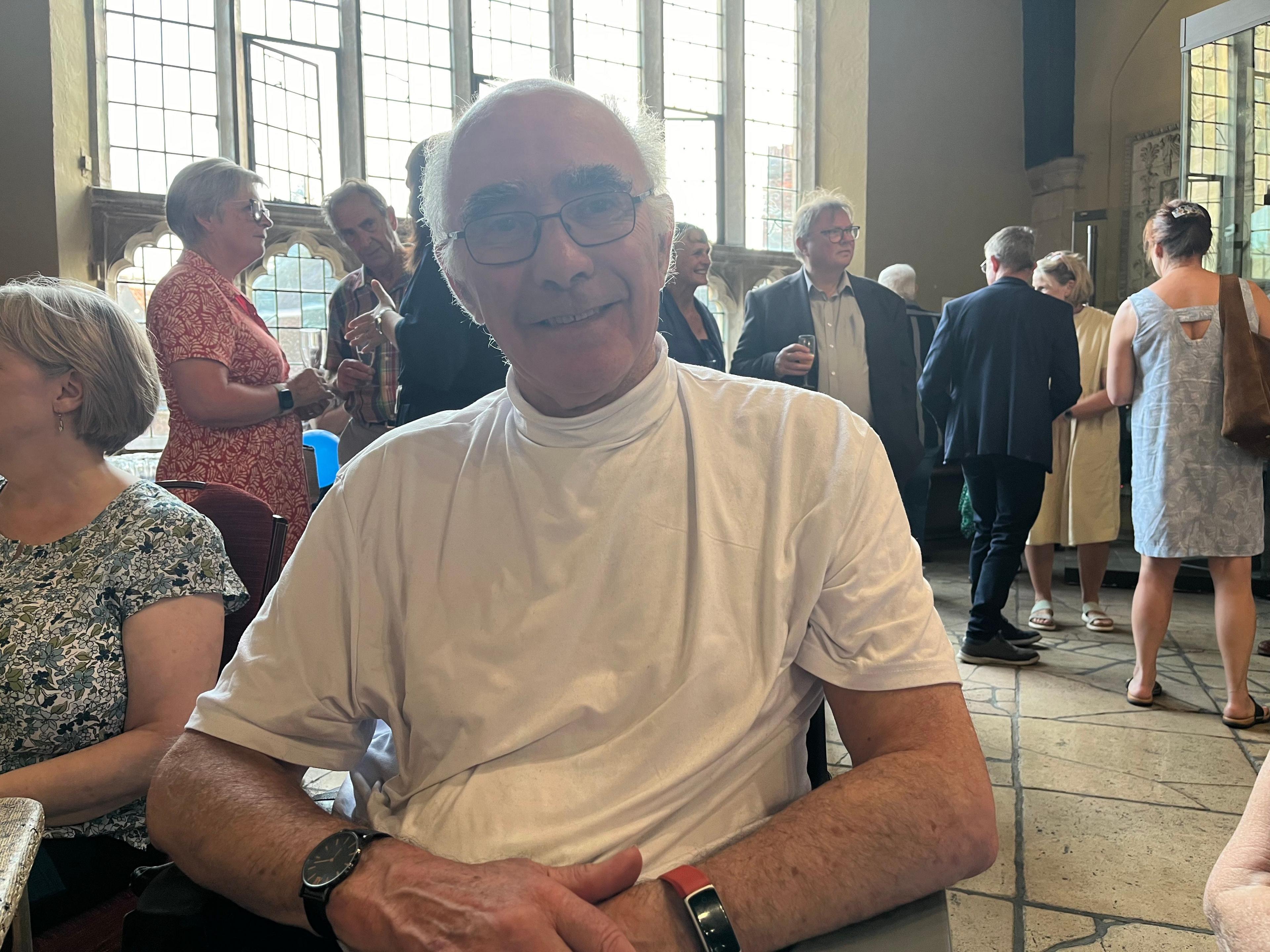 Richard Gowland sitting in King's Lynn Town Hall He is wearing a white T-shirt and glasses