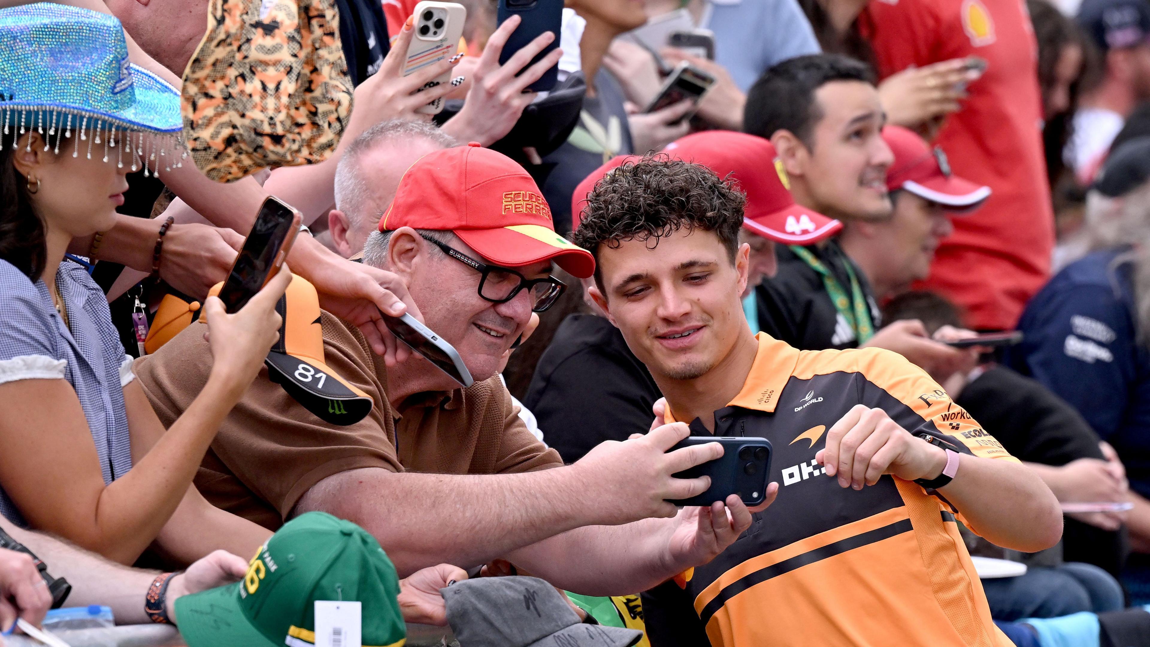 Lando Norris poses for a selfie with fans before first practice for the Australian Grand Prix