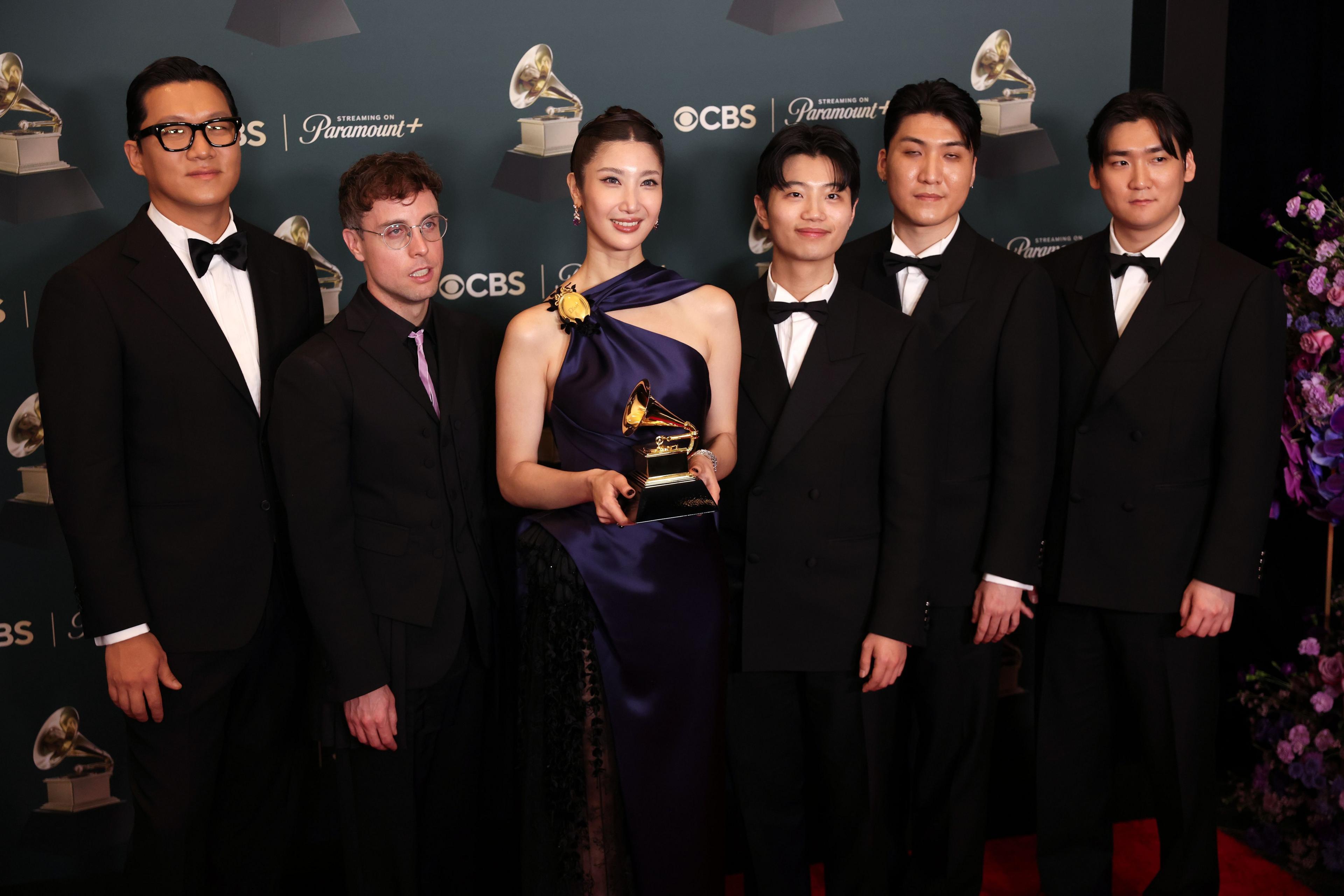 The team from 'KPop Demon Hunters' poses in the press room with the award for Best Song Written For Visual media for 'Golden'