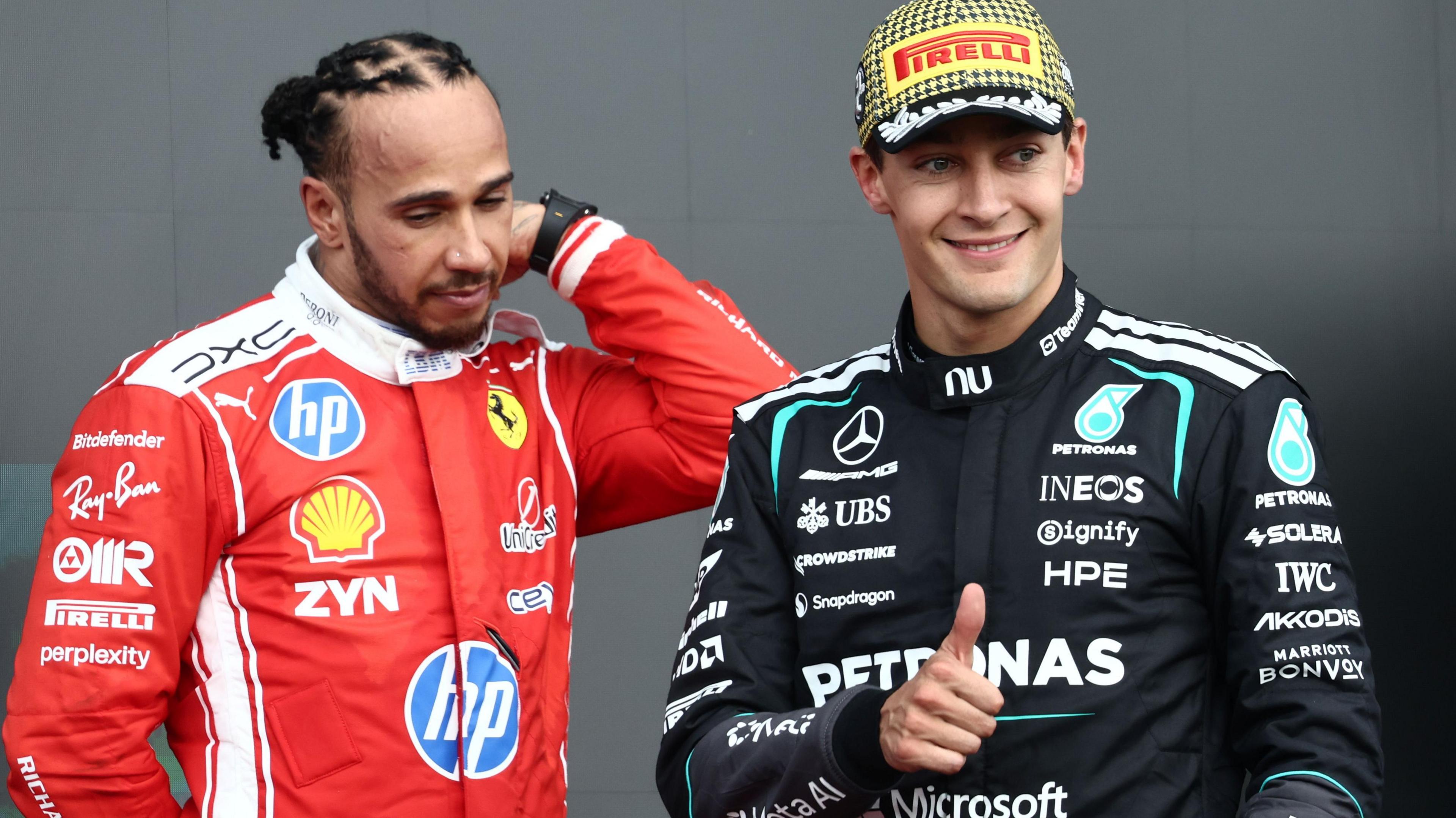 Mercedes driver George Russell gives the thumbs-up signal while stood next to Ferrari's Lewis Hamilton following the British Grand Prix