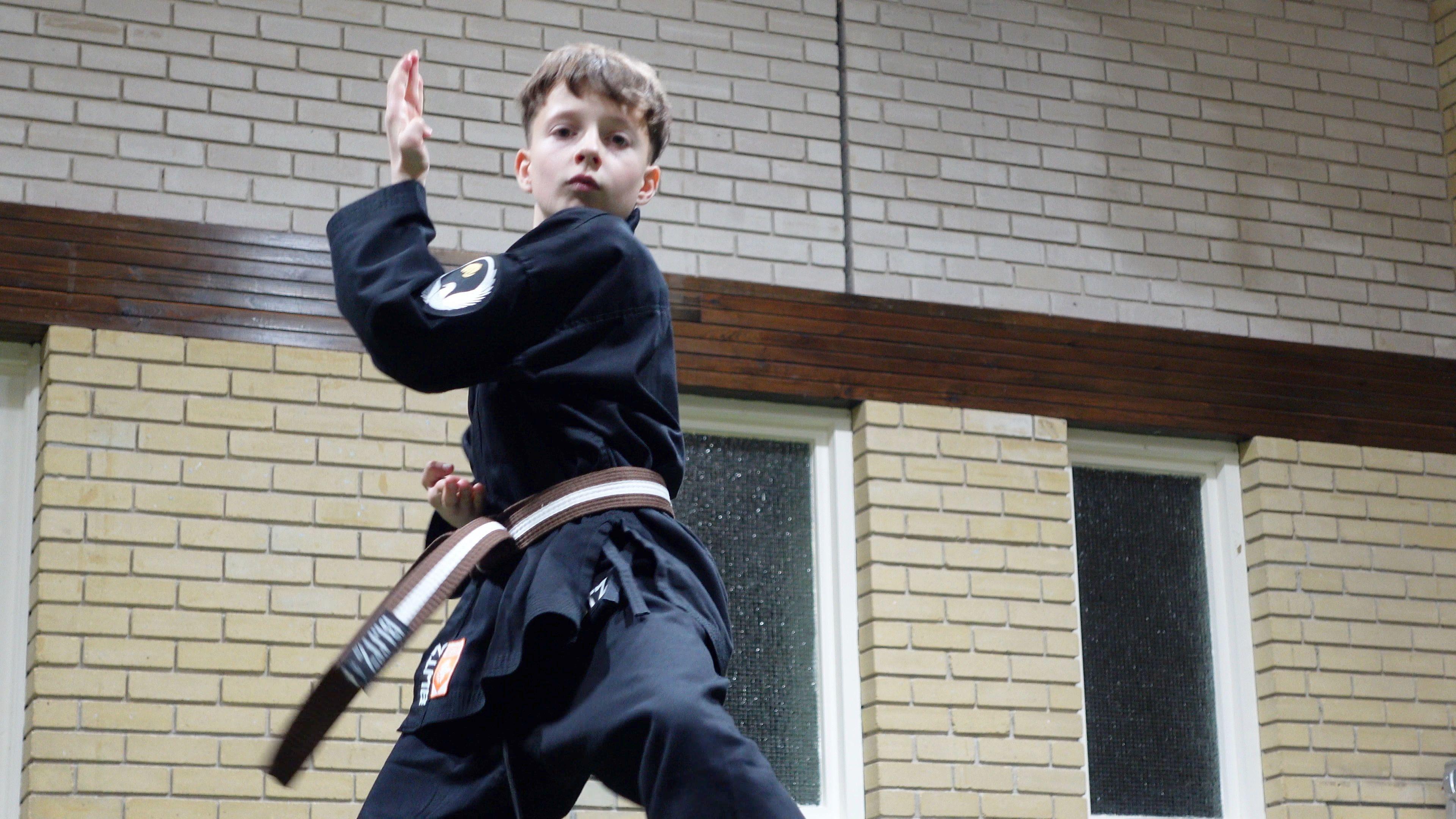 Seb in a black karate costume in a karate pose