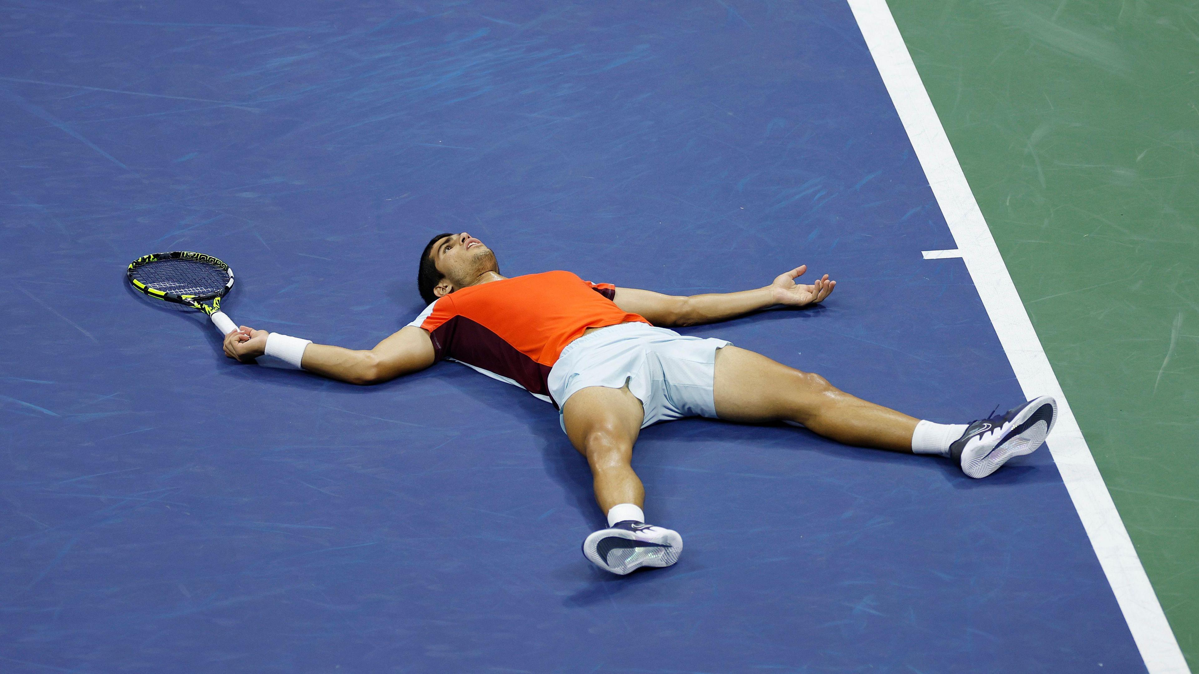 Carlos Alcaraz lies on Arthur Ashe Stadium after beating Jannik Sinner in the 2022 US Open quarter-finals