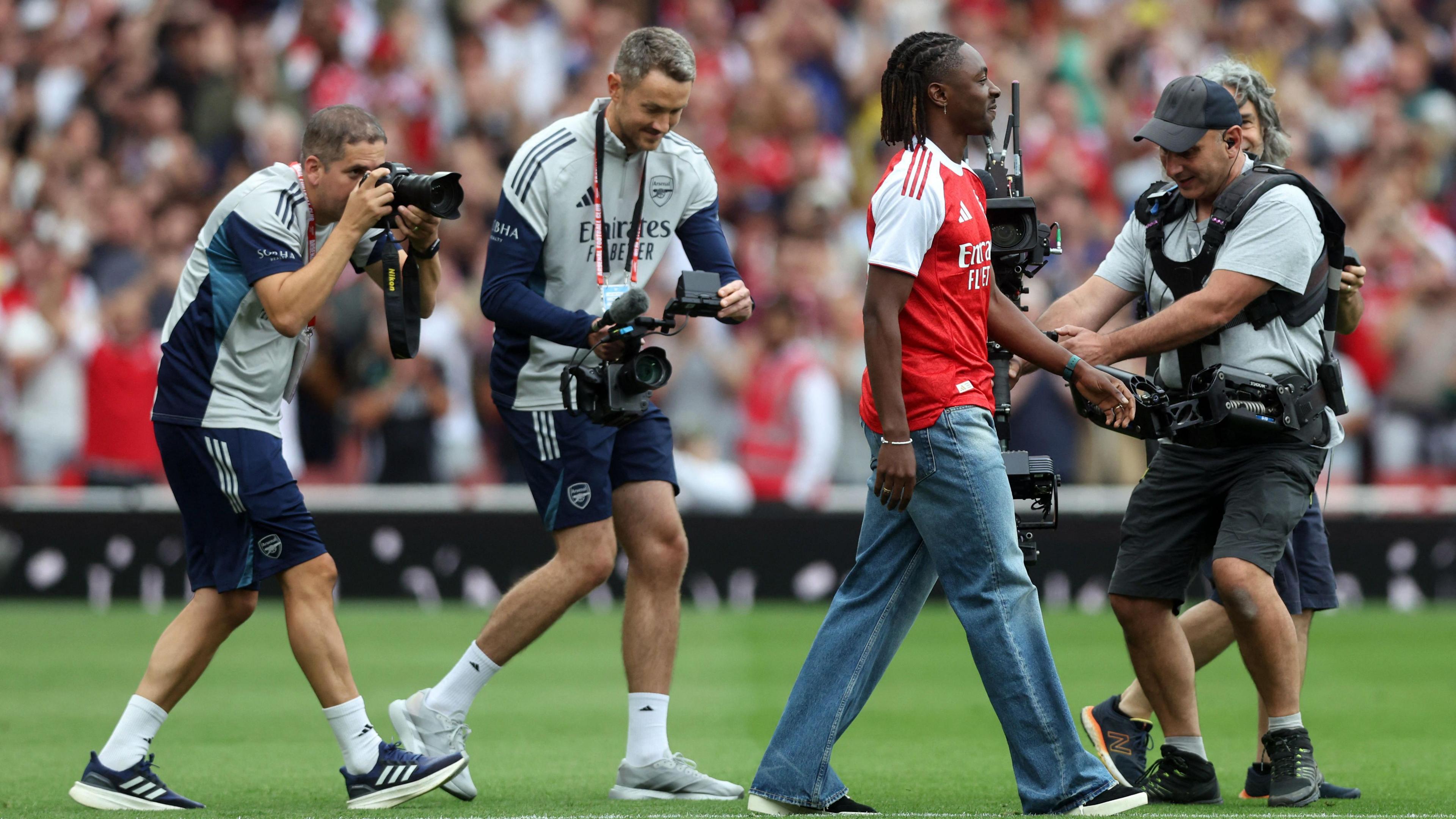 Eberechi Eze walking out onto the pitch in his Arsenal shirt being photographed.