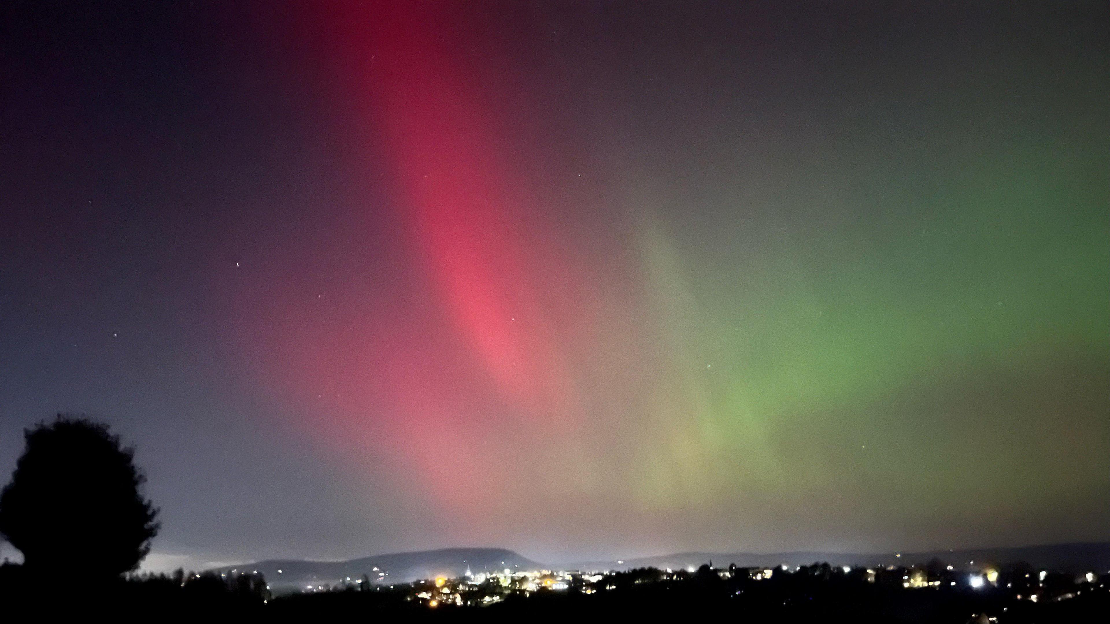 Red and green Northern Lights over Pendle Hill