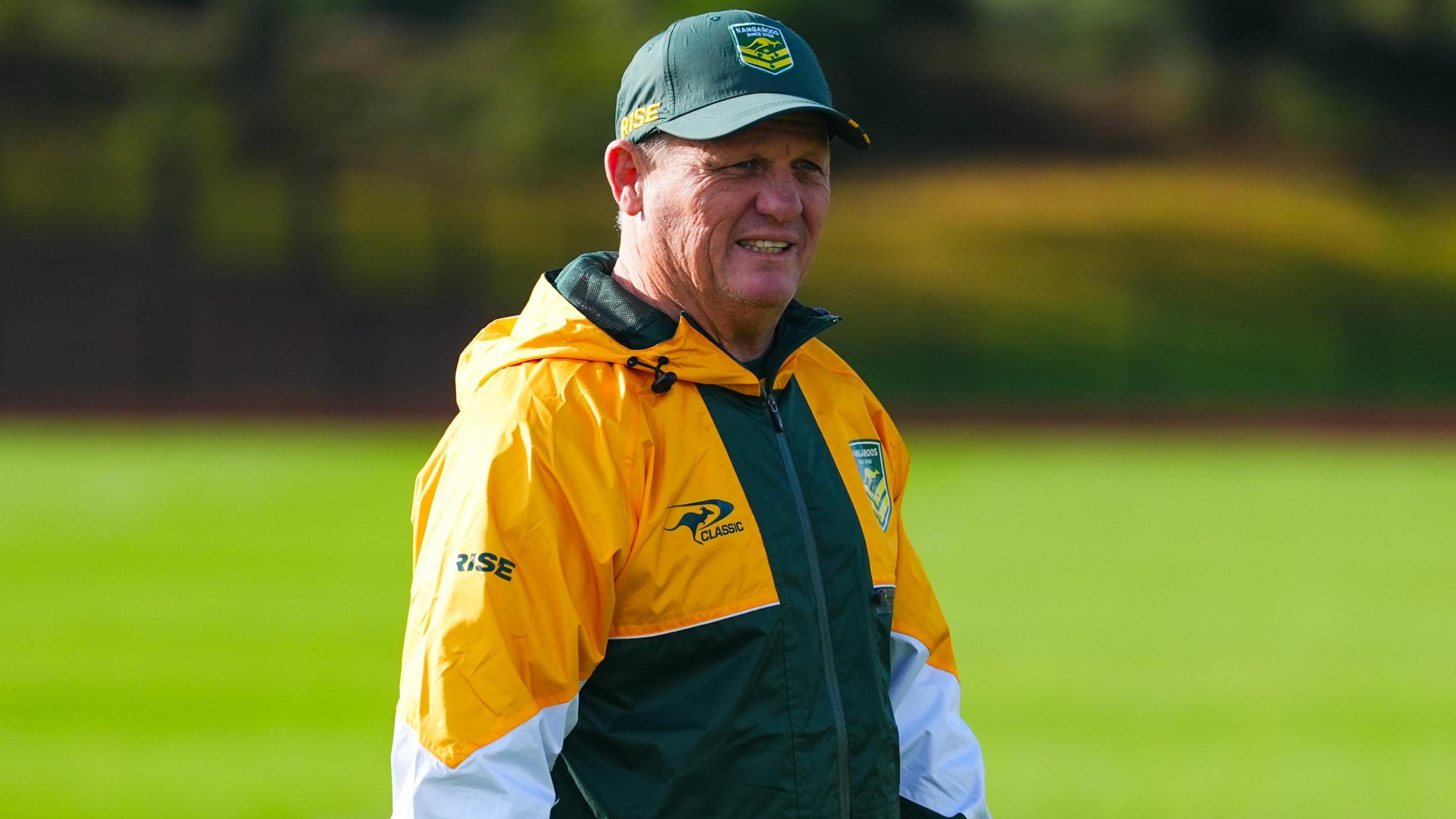 Kevin Walters, wearing a green Australia hat and a yellow and green tracksuit top during an Australia training session