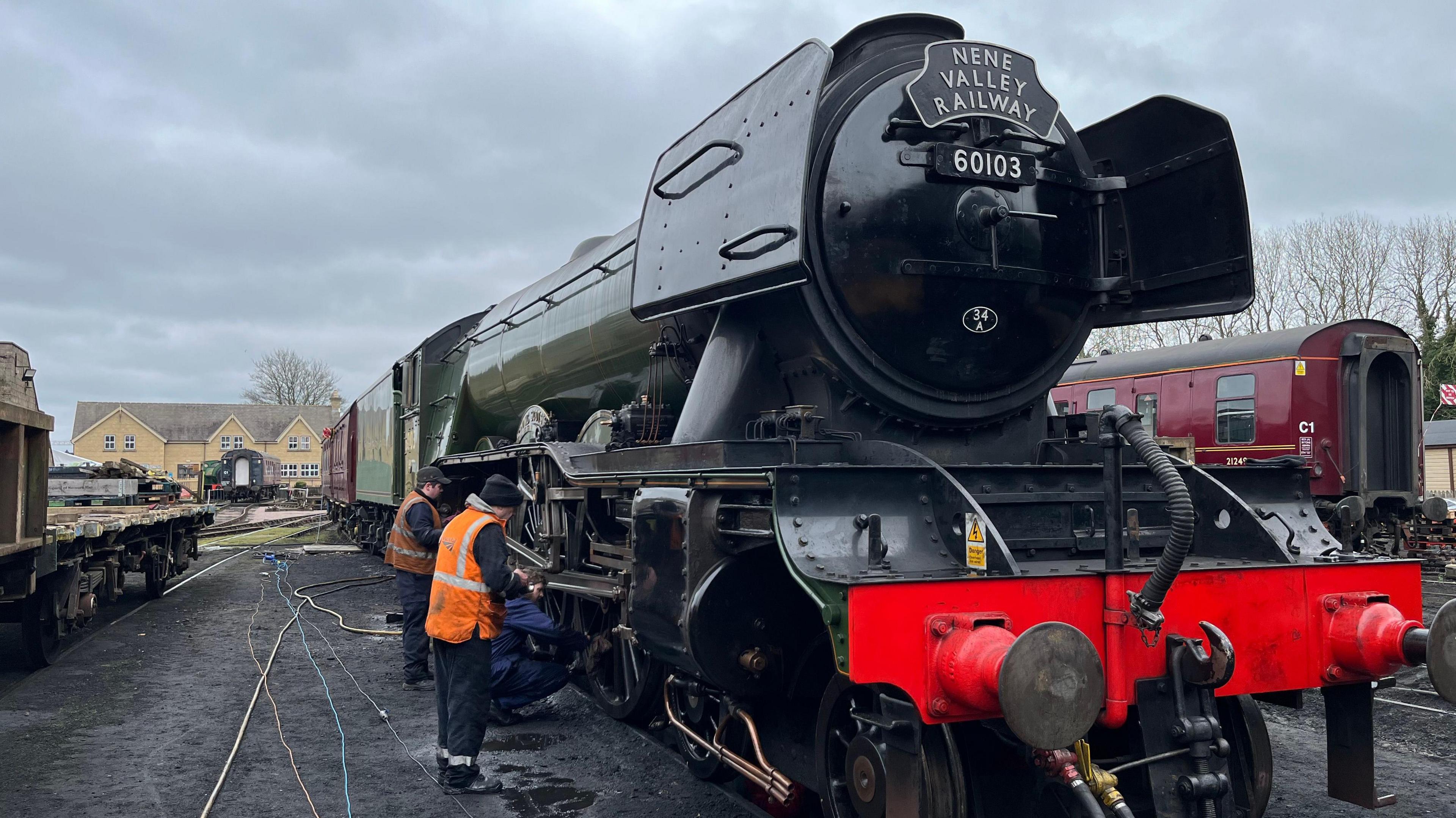 Black and green steam engine parked on the railway tracks 