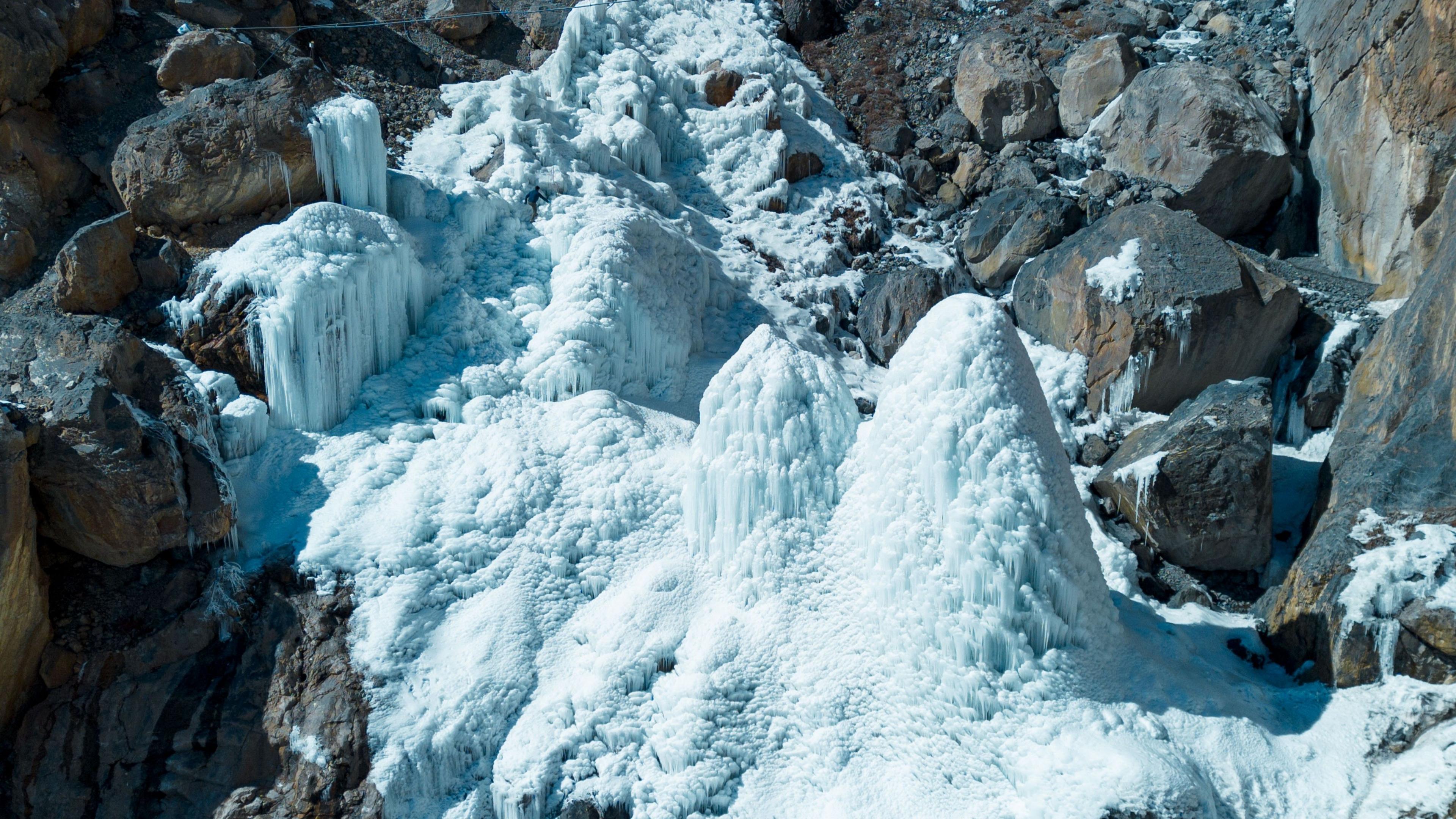 Towers of ice stand in a rocky gorge.