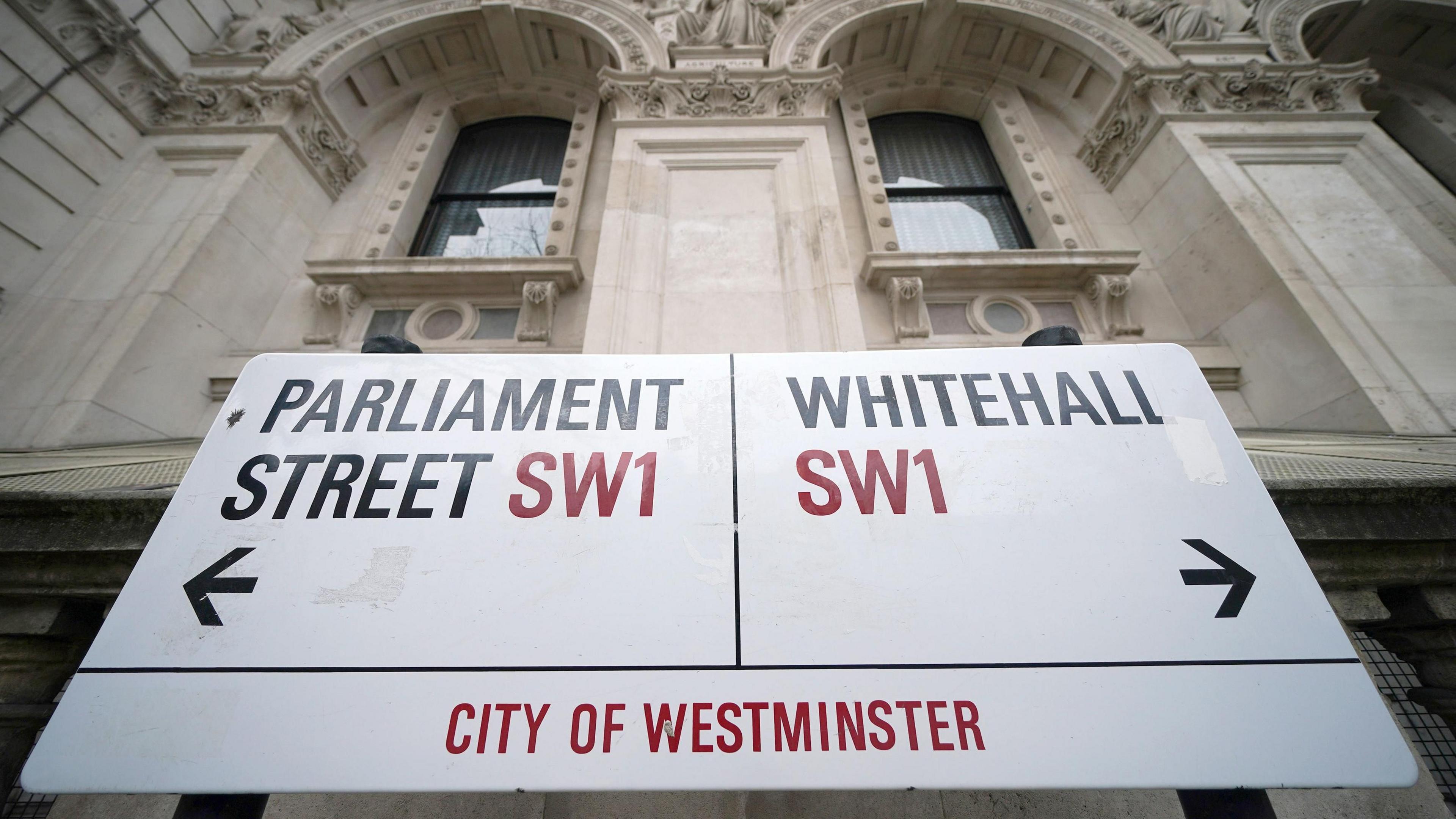 A street sign giving directions to Parliament Street and Whitehall in London