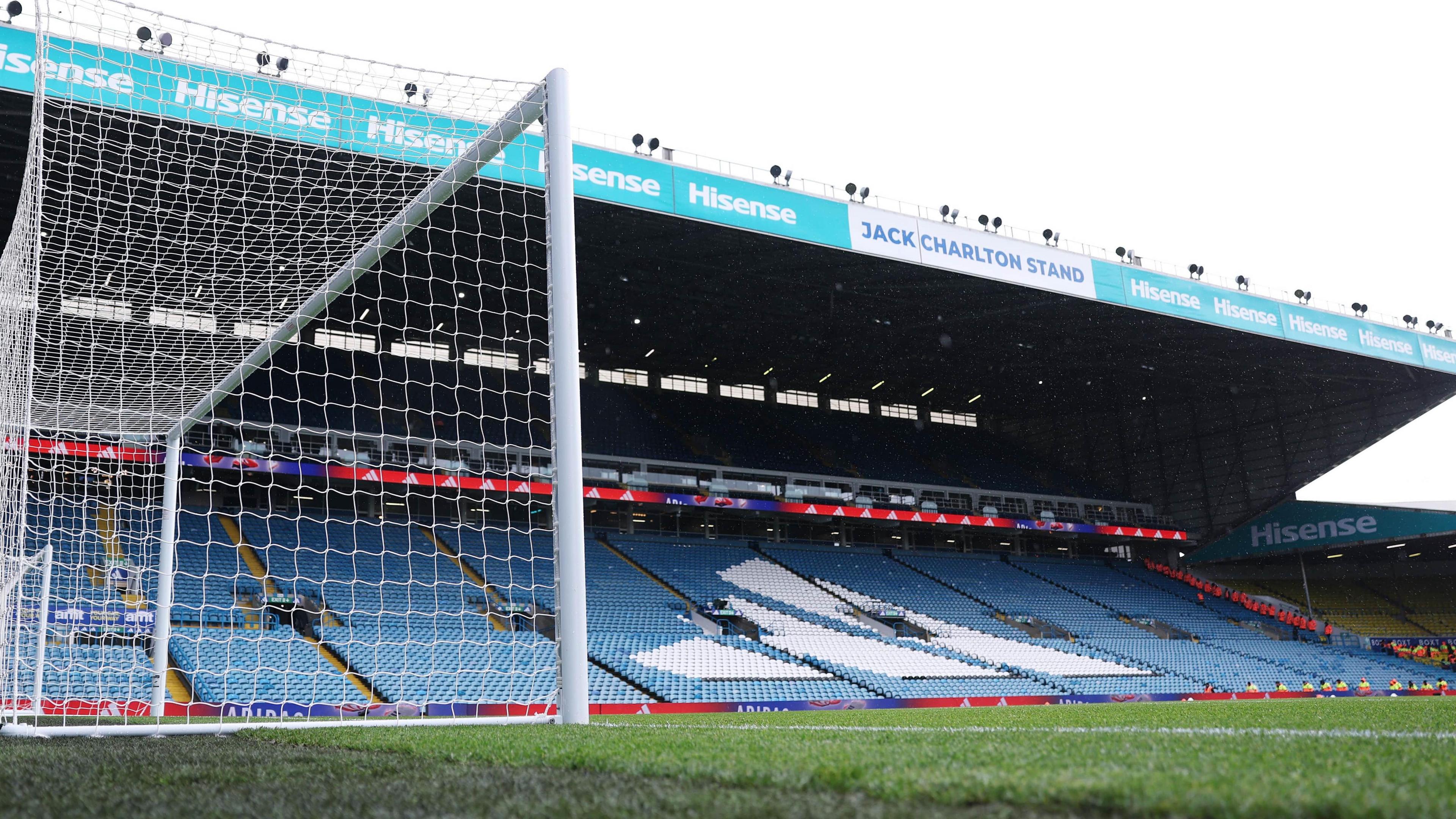 A view of an empty Elland Road from the pitch. Lots of blue and white seats can be seen.