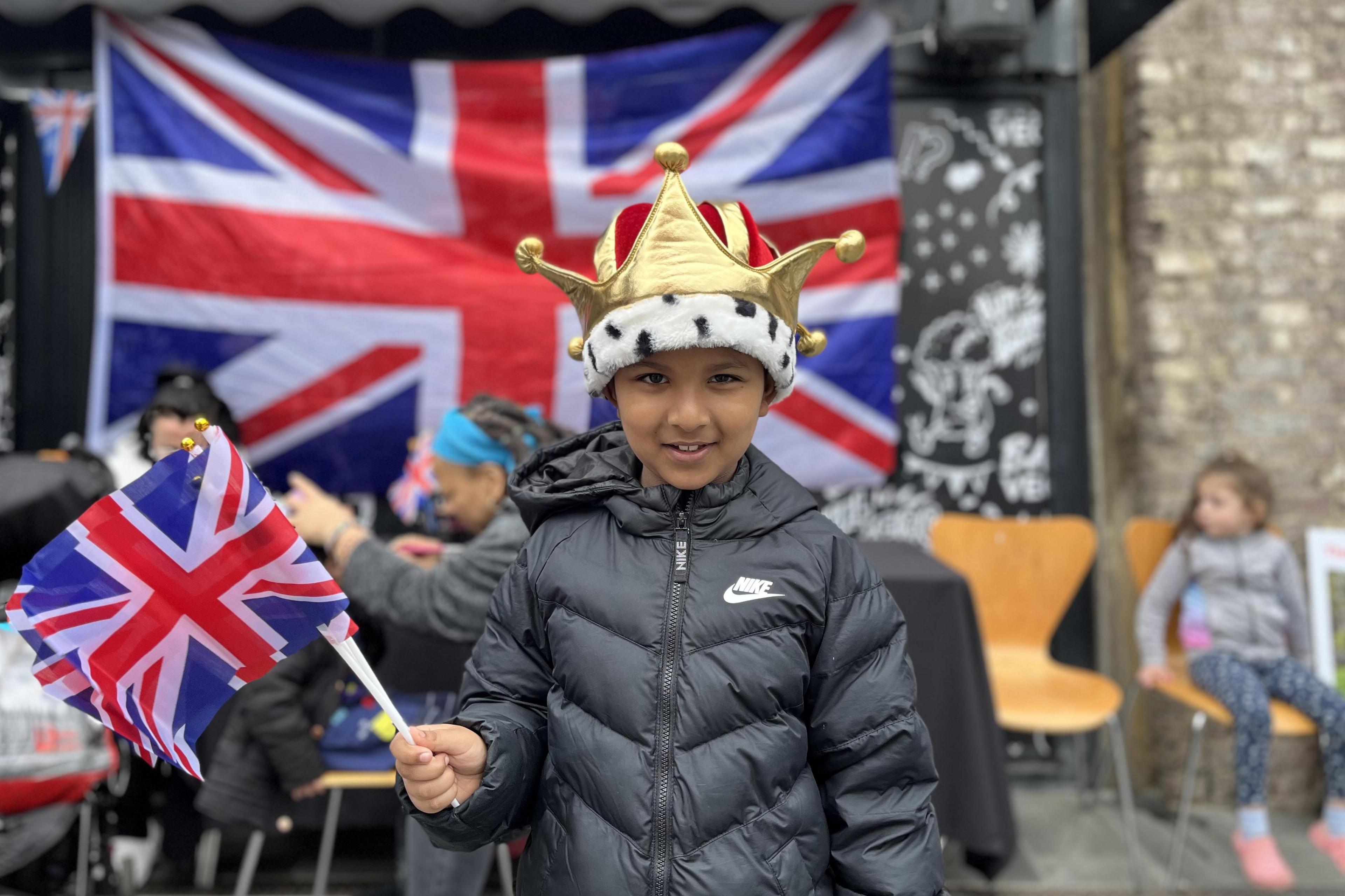 The child of a volunteer waives a flag in his crown