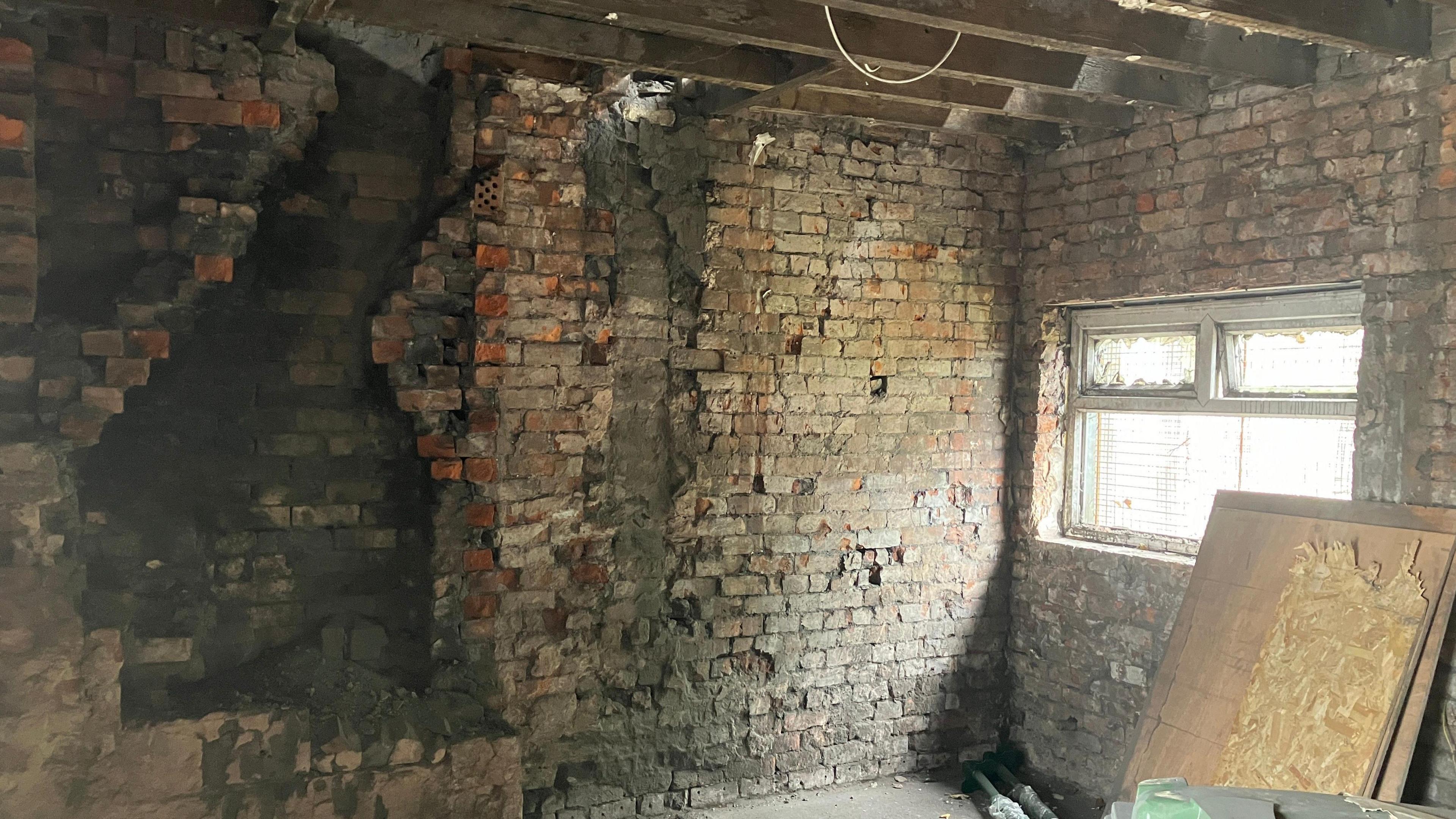 Empty home with exposed beams in the ceiling and exposed brick walls