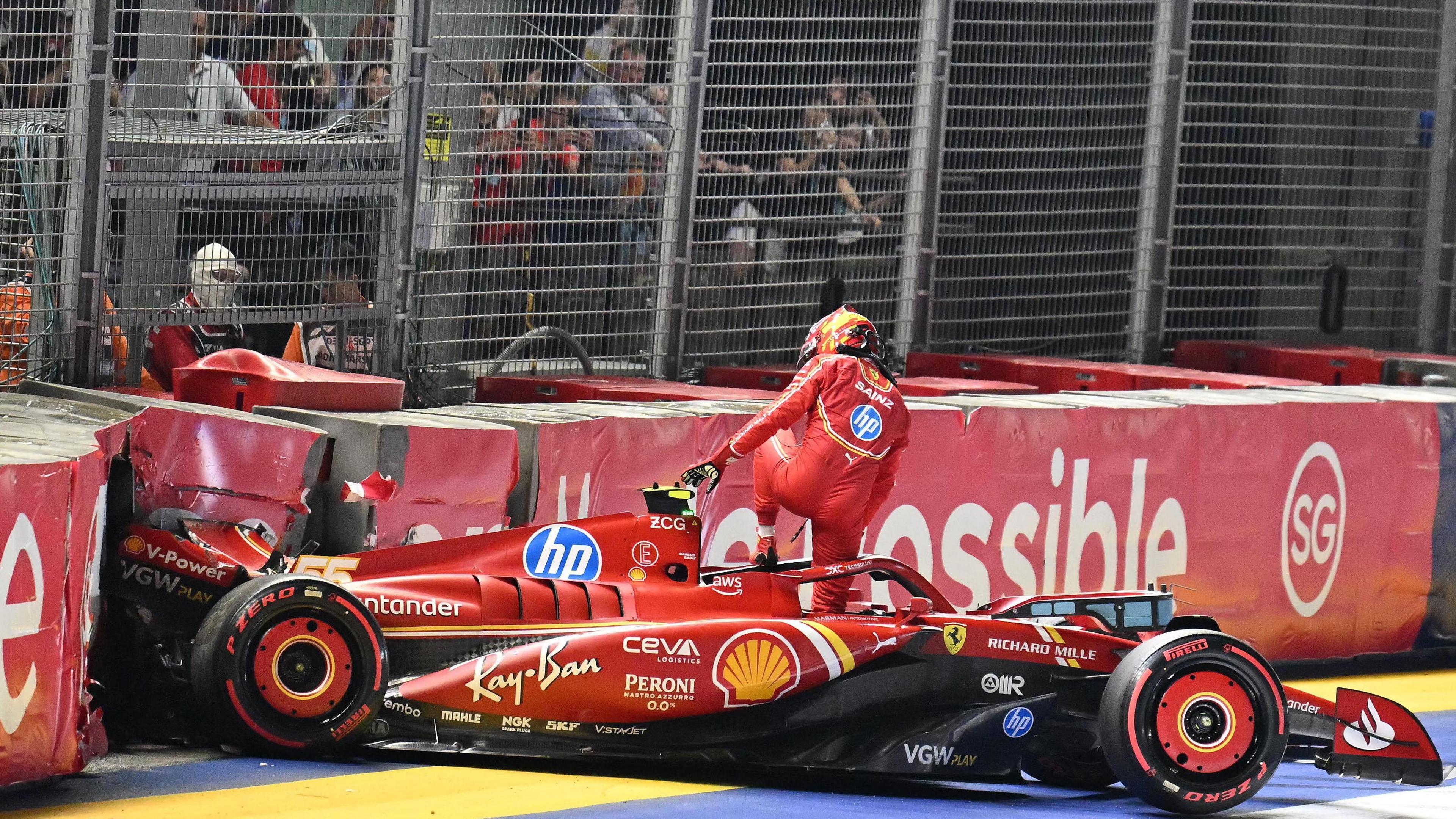 Carlos Sainz climbs out of his Ferrari after he crashed into the barriers during qualifying