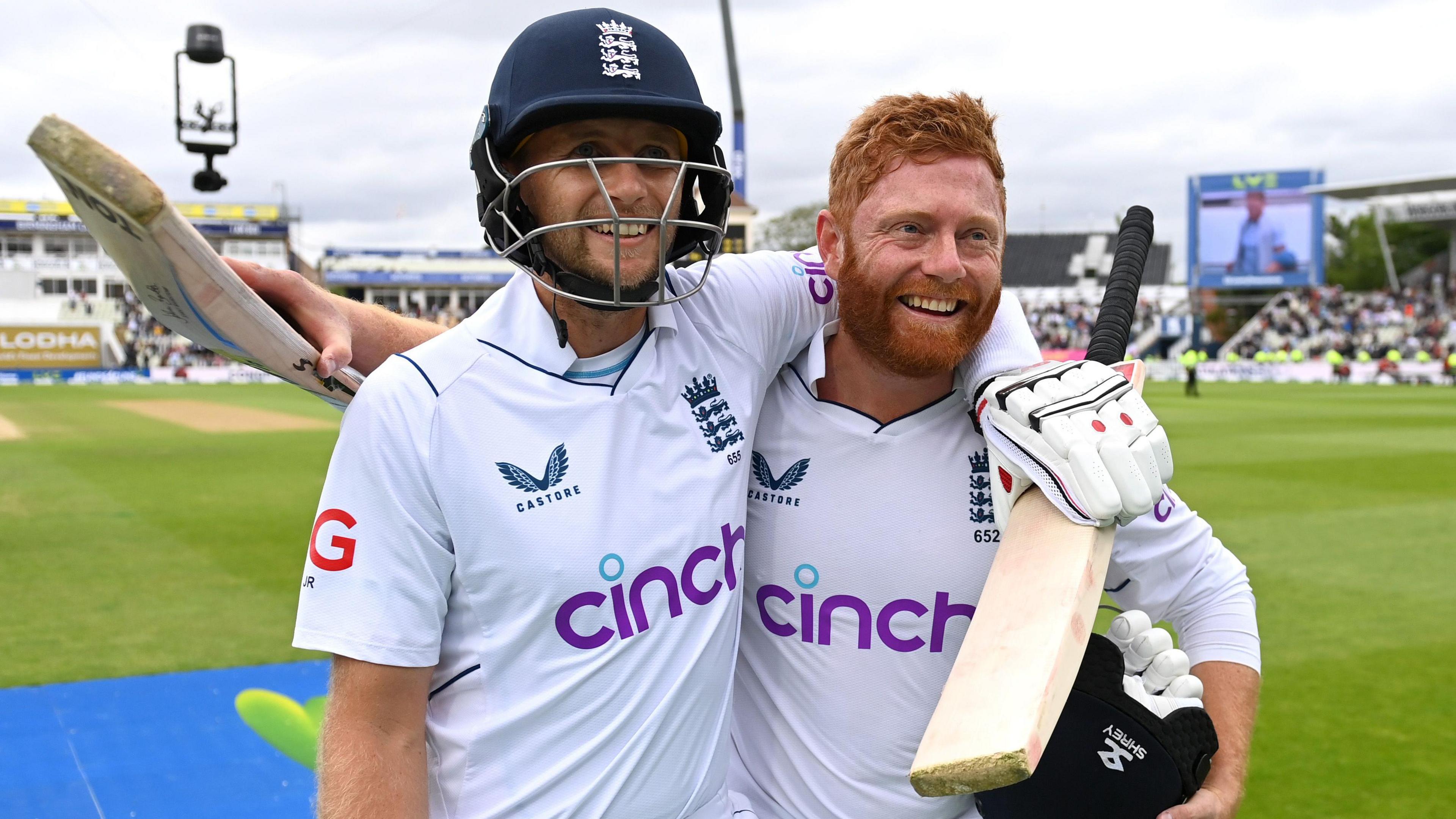 Joe Root and Jonny Bairstow both smiling with their arms around each other's shoulders as they walk off the pitch at Edgbaston in 2022