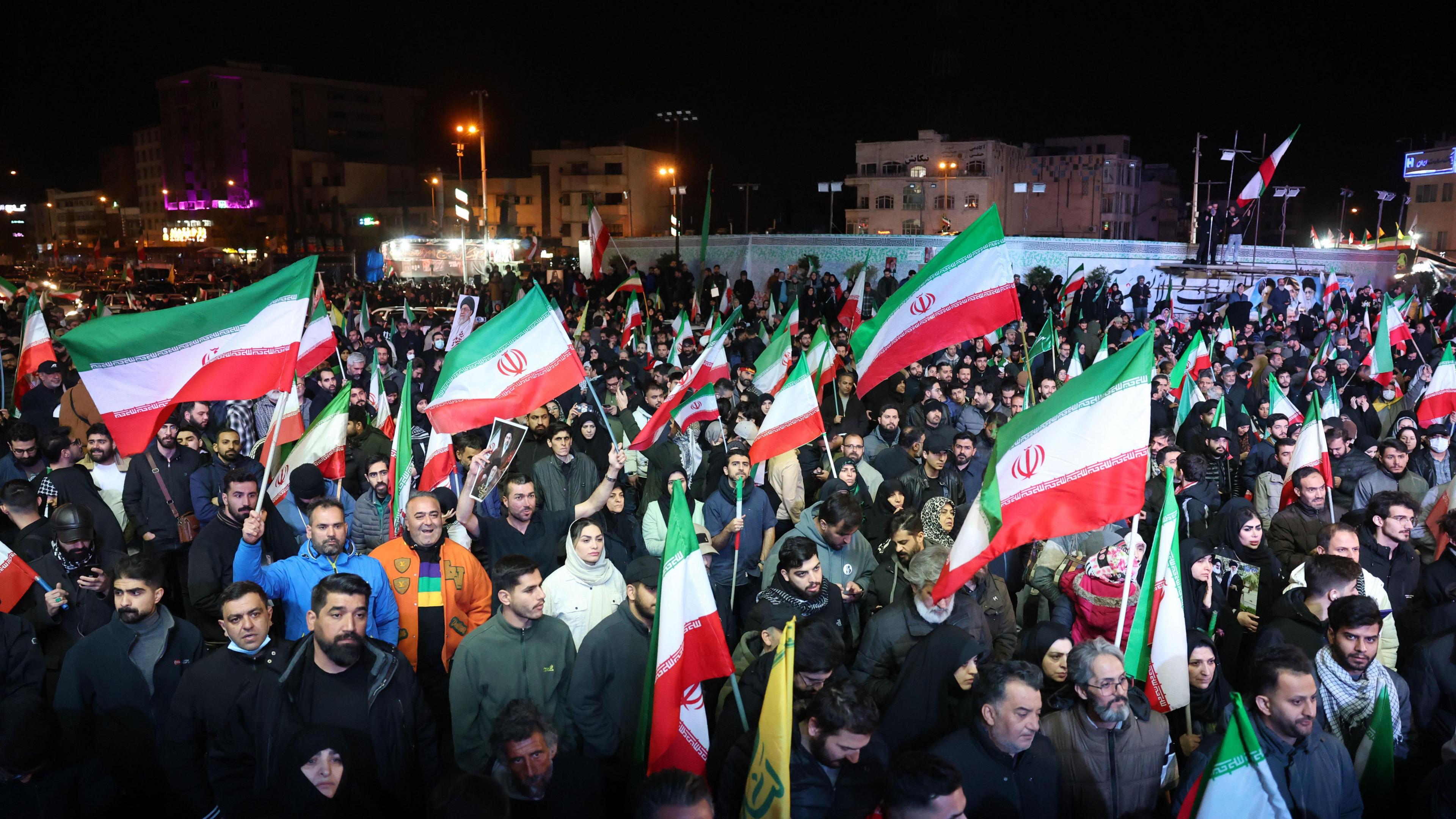 Iranians wave flags in Tehran, following the announcement of a two-week ceasefire.