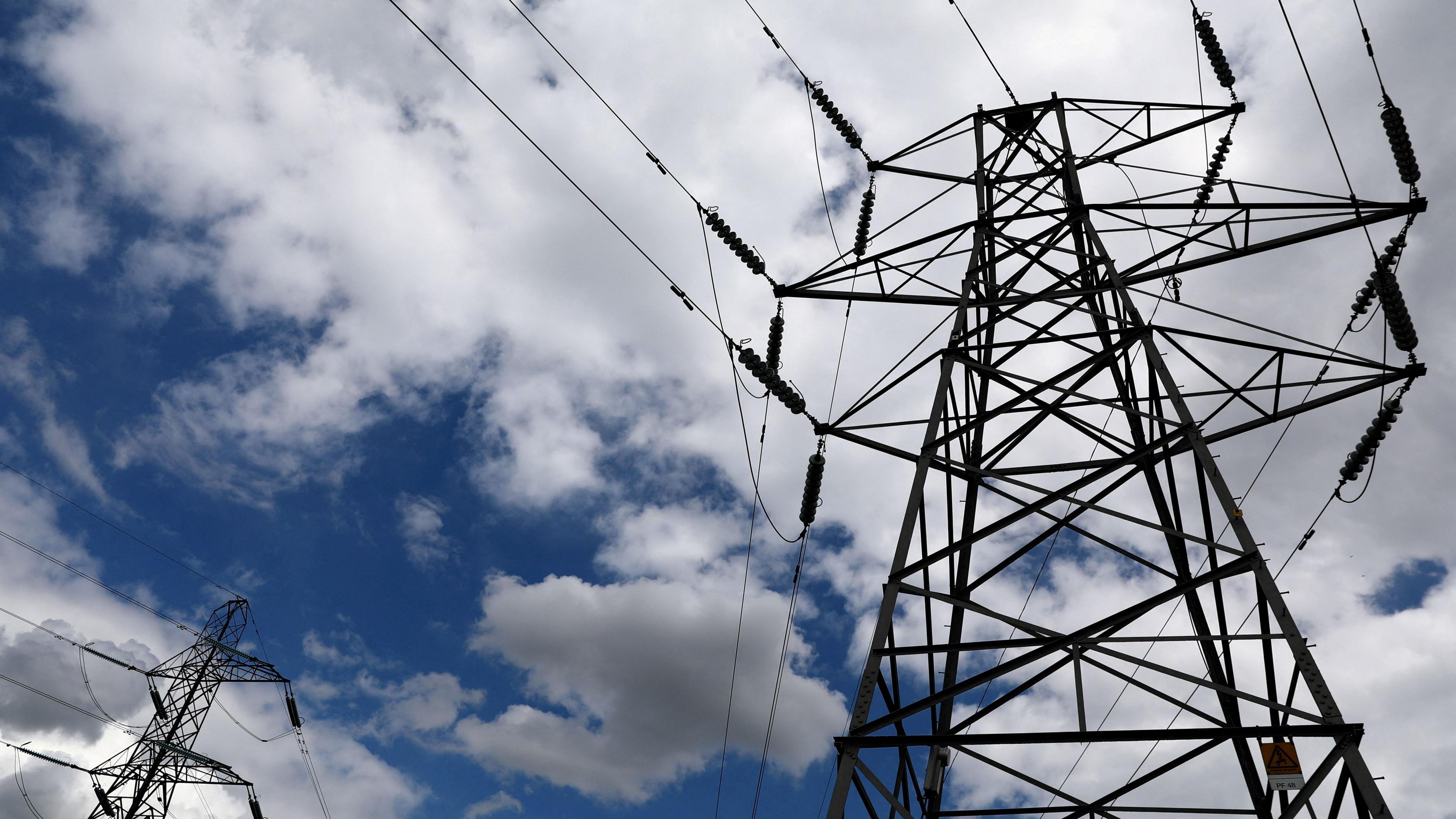A photo of a pylon, looking from the ground up. Much of the image is of a cloudy sky