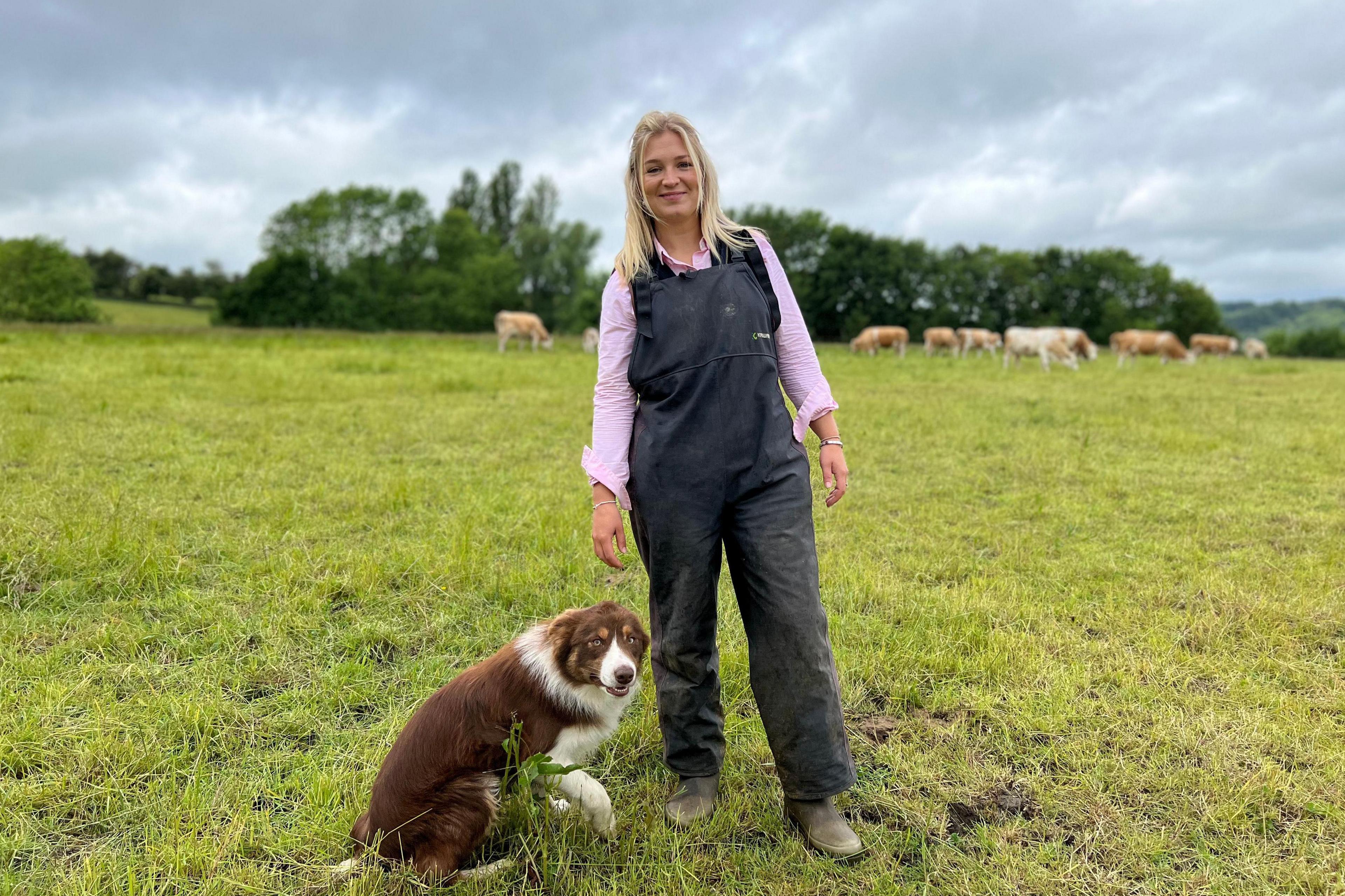 Harriet with her dog, with cows in the background