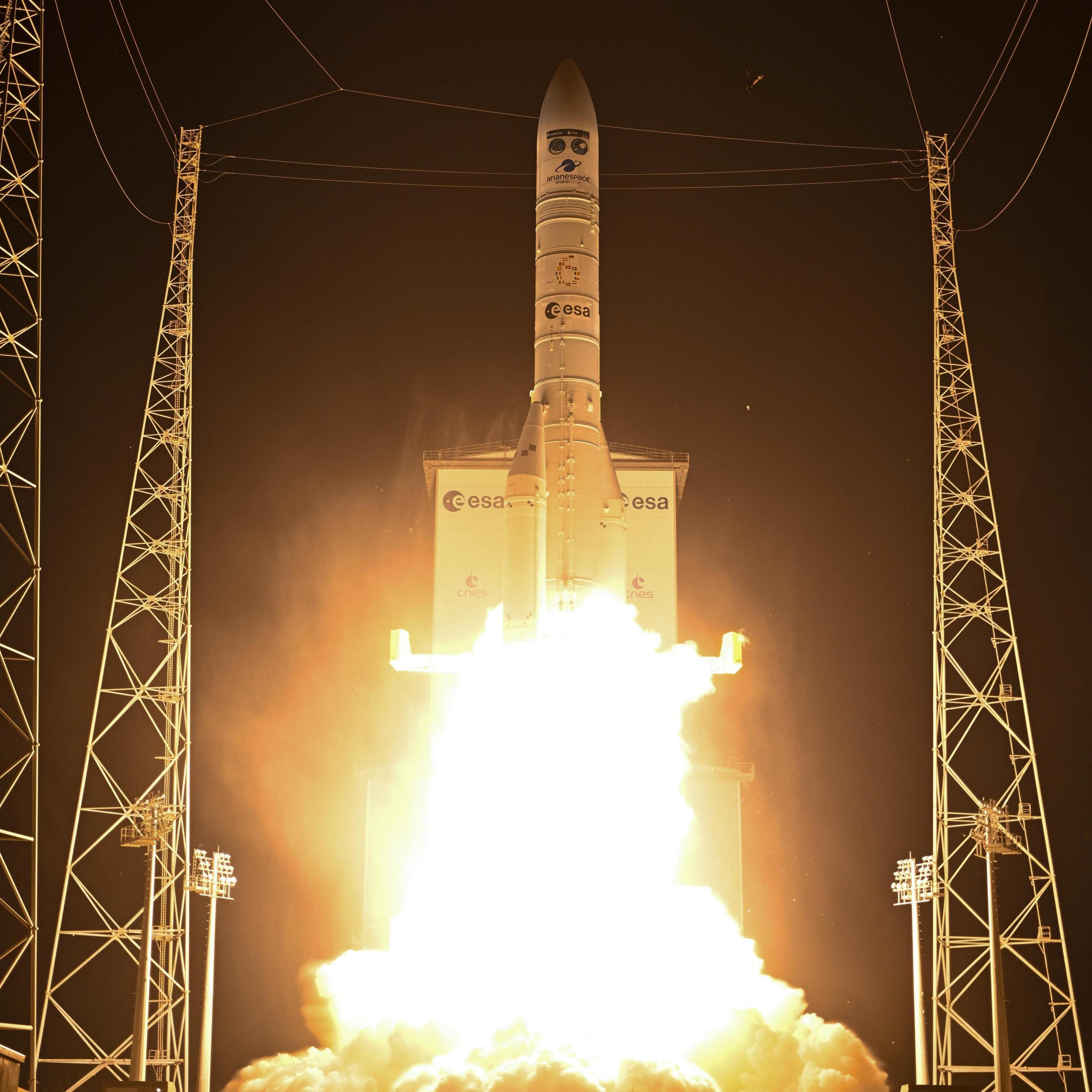 A white rocket with bright red flames emitting from the bottom.