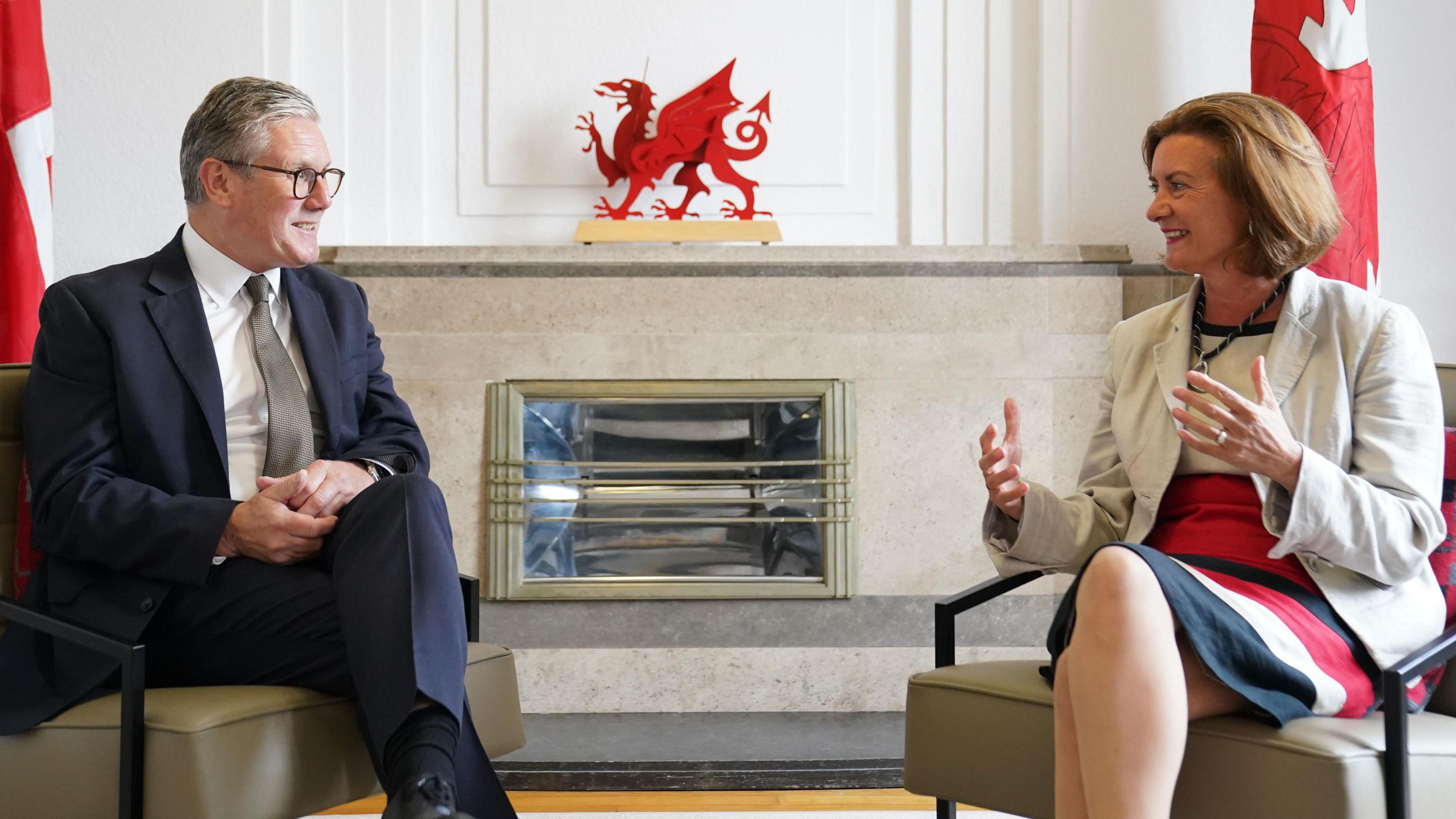 Sir Keir Starmer and Eluned Morgan sat in front of a fire place in Cathays Park