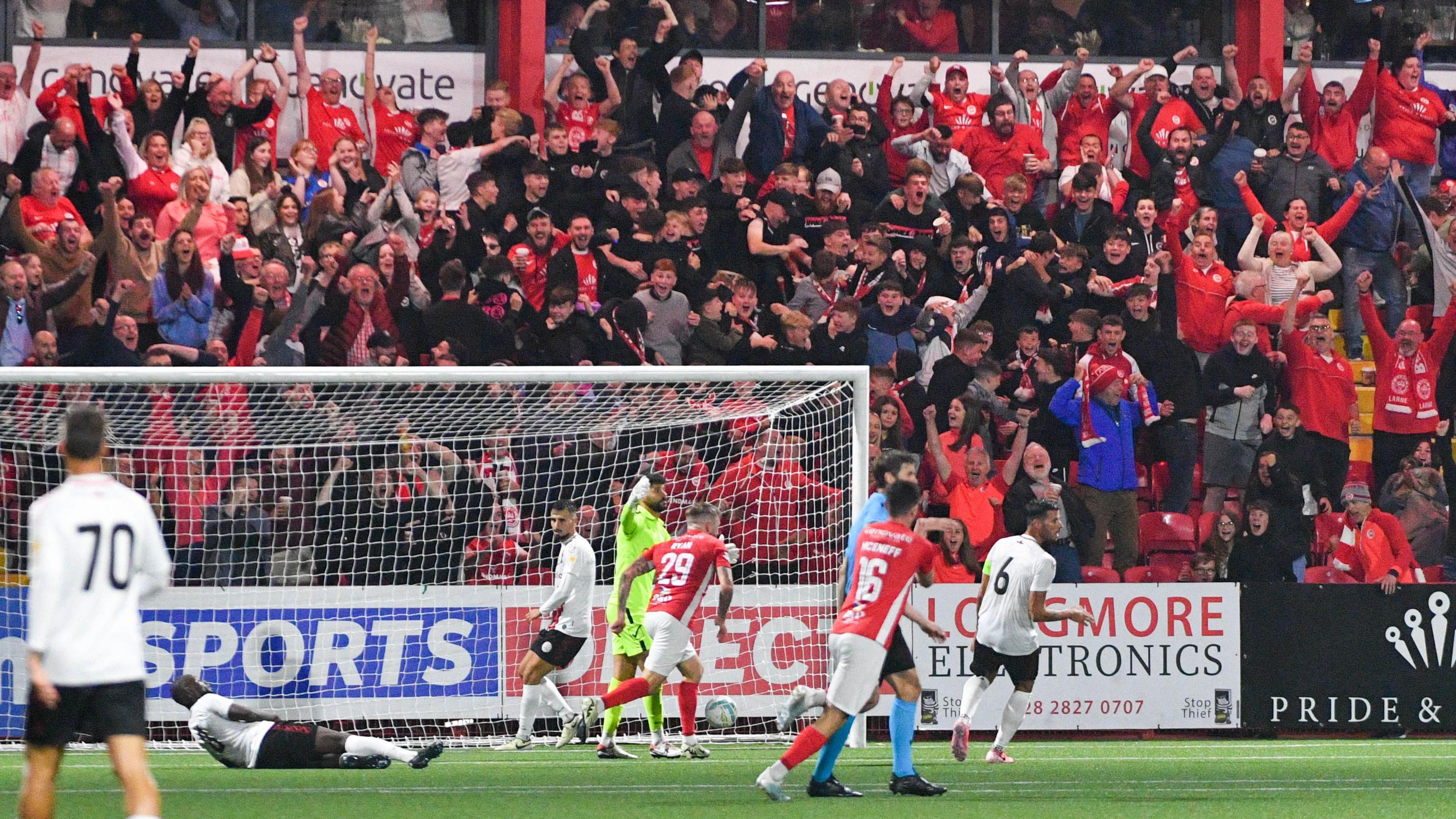 Larne players and fans celebrate Andy Ryan's historic goal