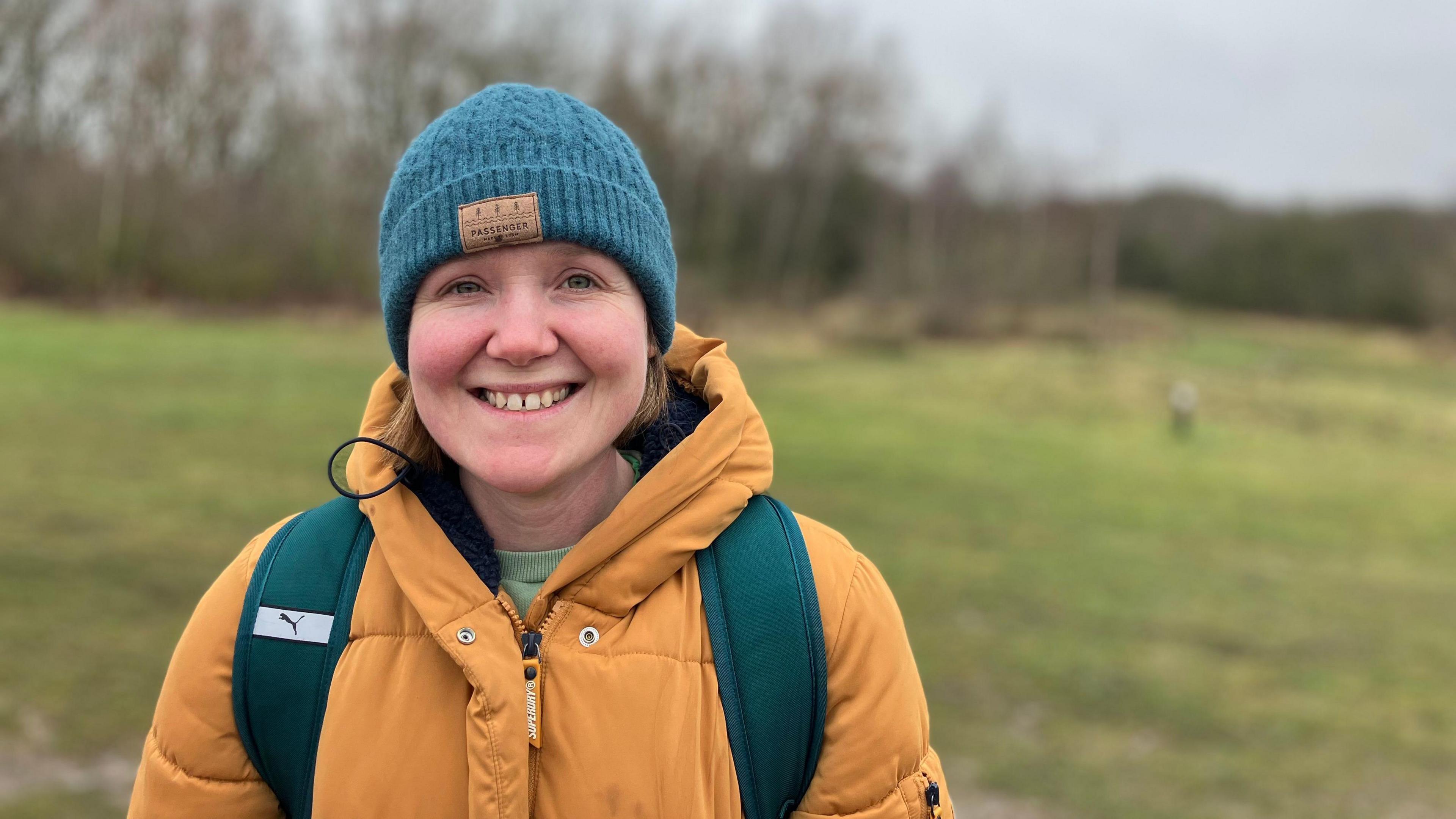 Ruth Gentle, stood in front of an area of grass with trees in the background