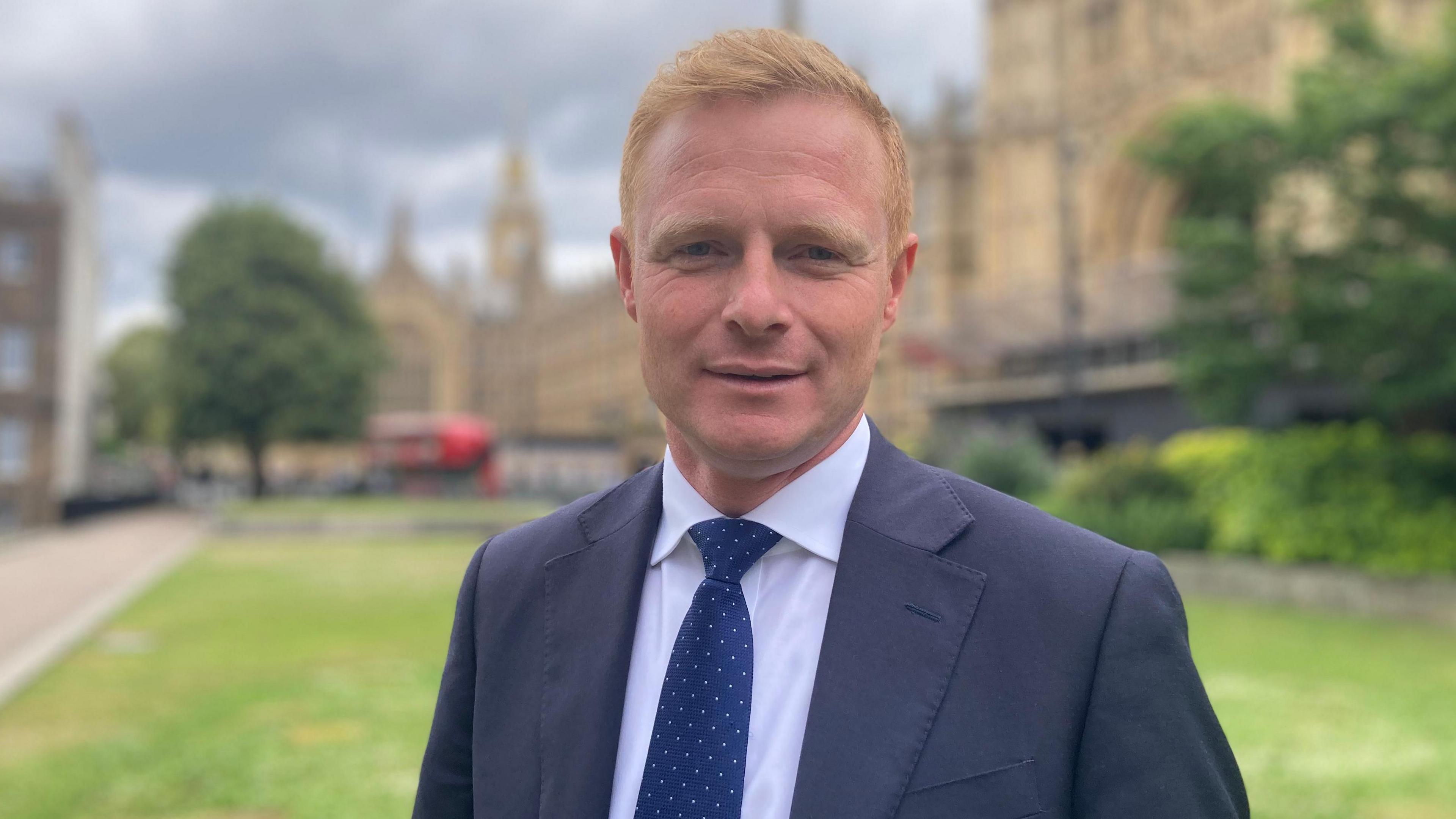 Robbie Moore wearing a blue suit and tie