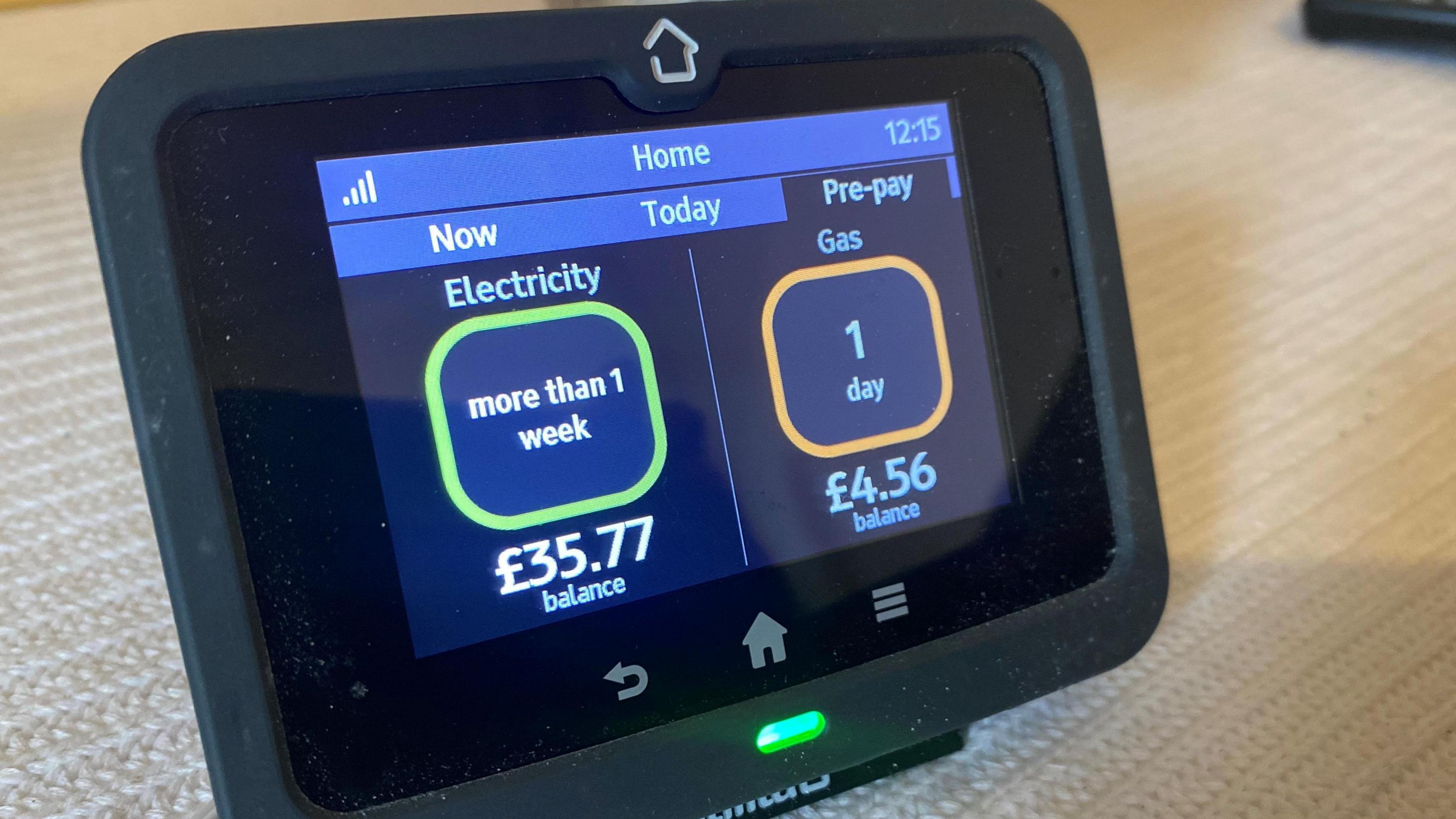 A black smart prepayment meter with the display showing the amount of electricity consumed in a week along with the balance remaining in pounds on the left and on the right the amount of gas consumed along with the cash balance remaining