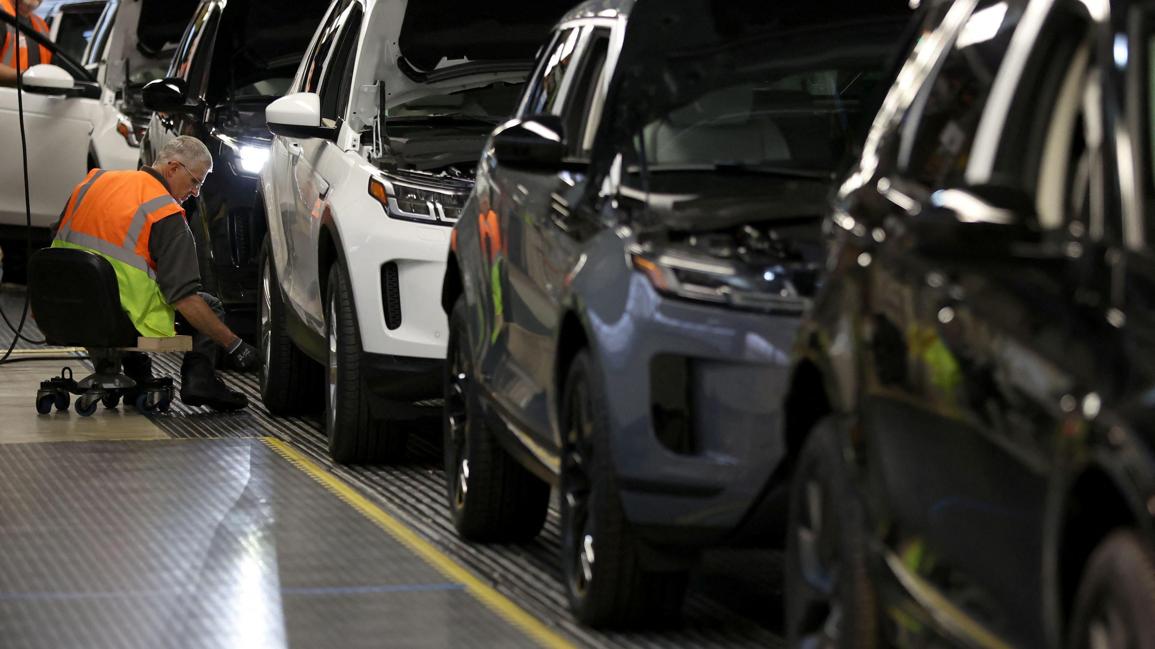 A staff member assembles Range Rover Evoque SUVs on the production line at Jaguar Land Rover's Halewood factory in Liverpool