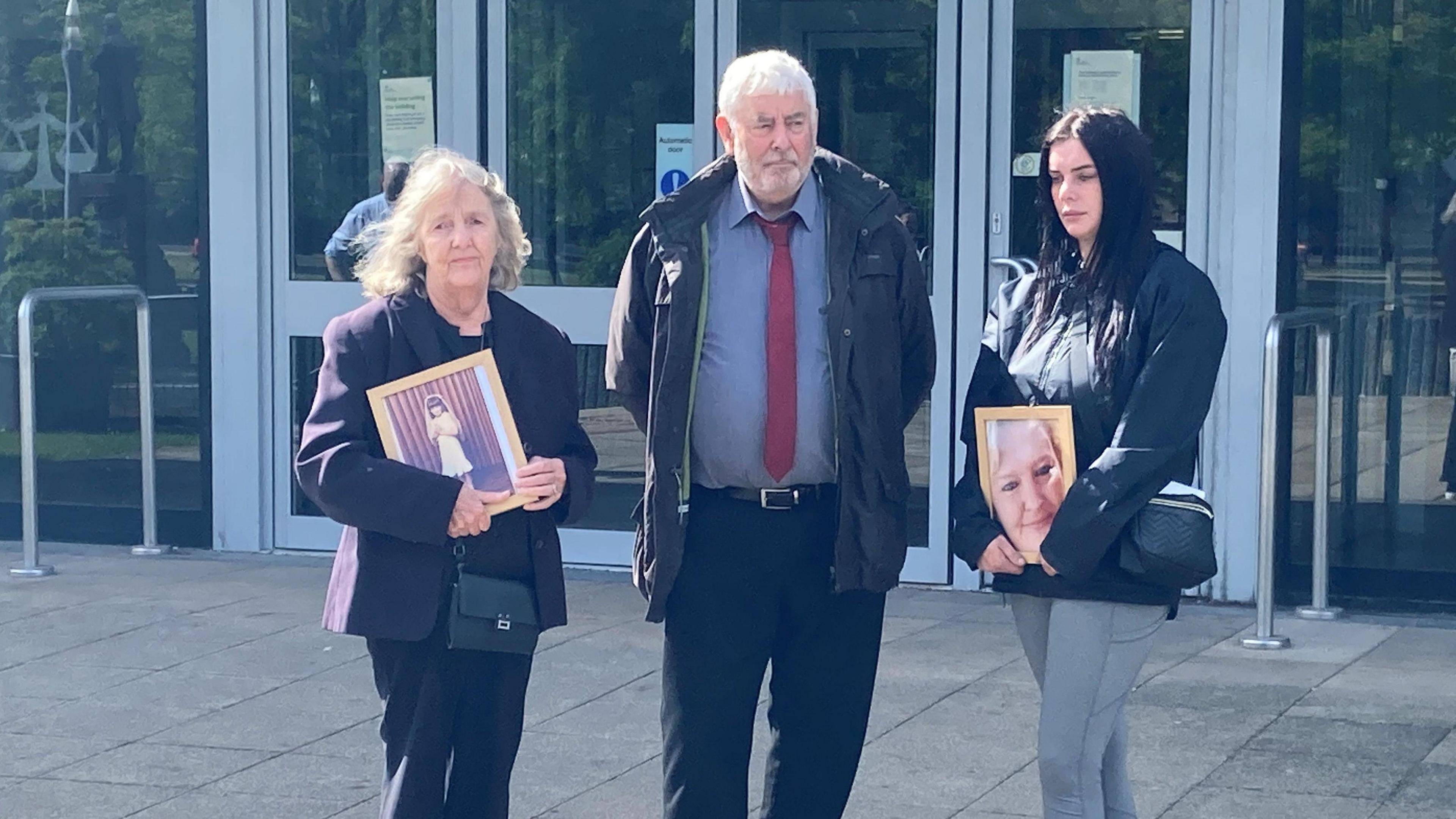 Jodey Whiting's family - with mother Joy Dove on the left - outside Teesside Coroner's Court as a second inquest into her death opens. Two of them are holding framed photos of Jodey.