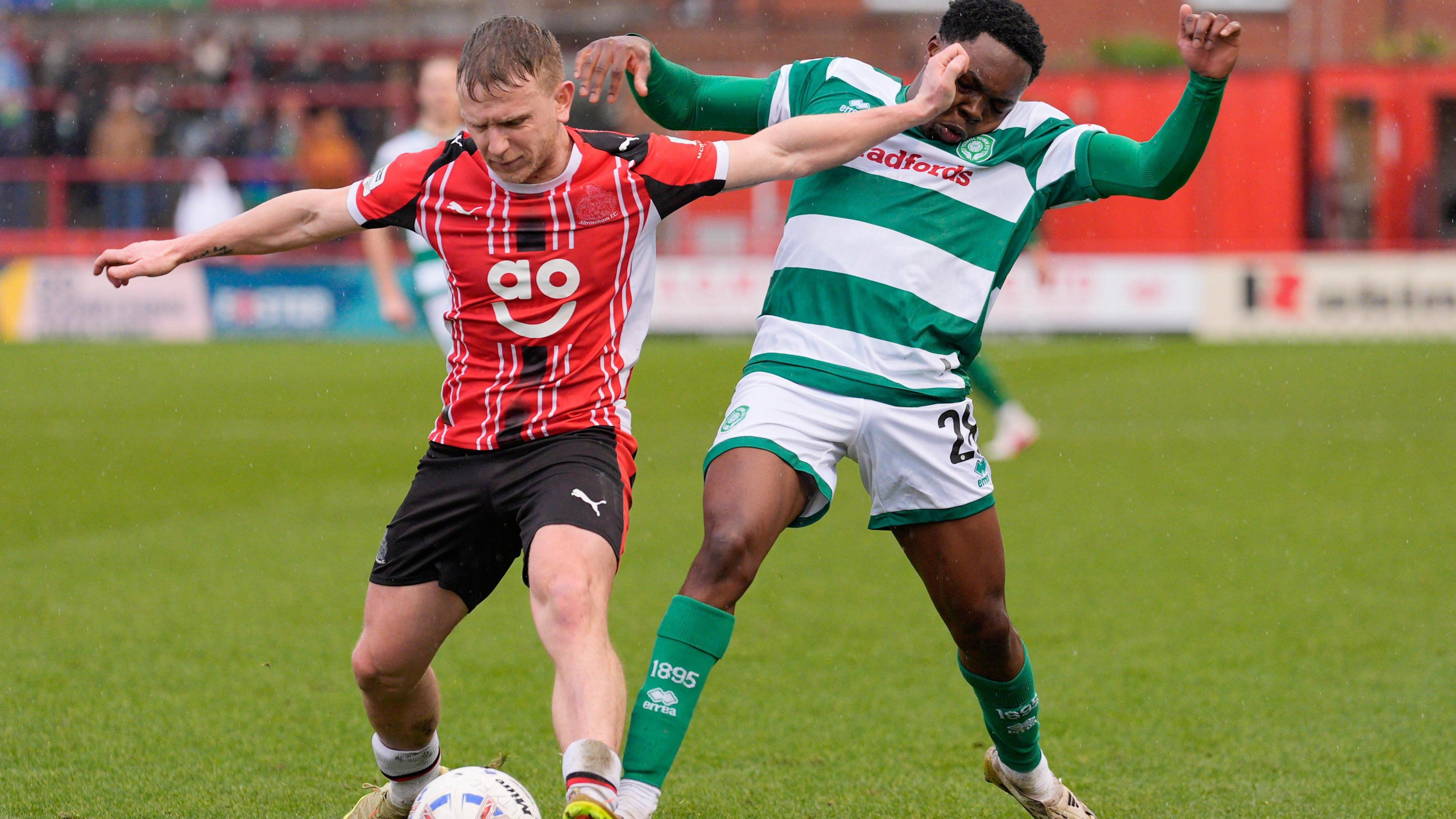 Matty Kosylo fends off Yeovil defender Dakarai Mafico with his arm while holding onto possession for Altrincham.
