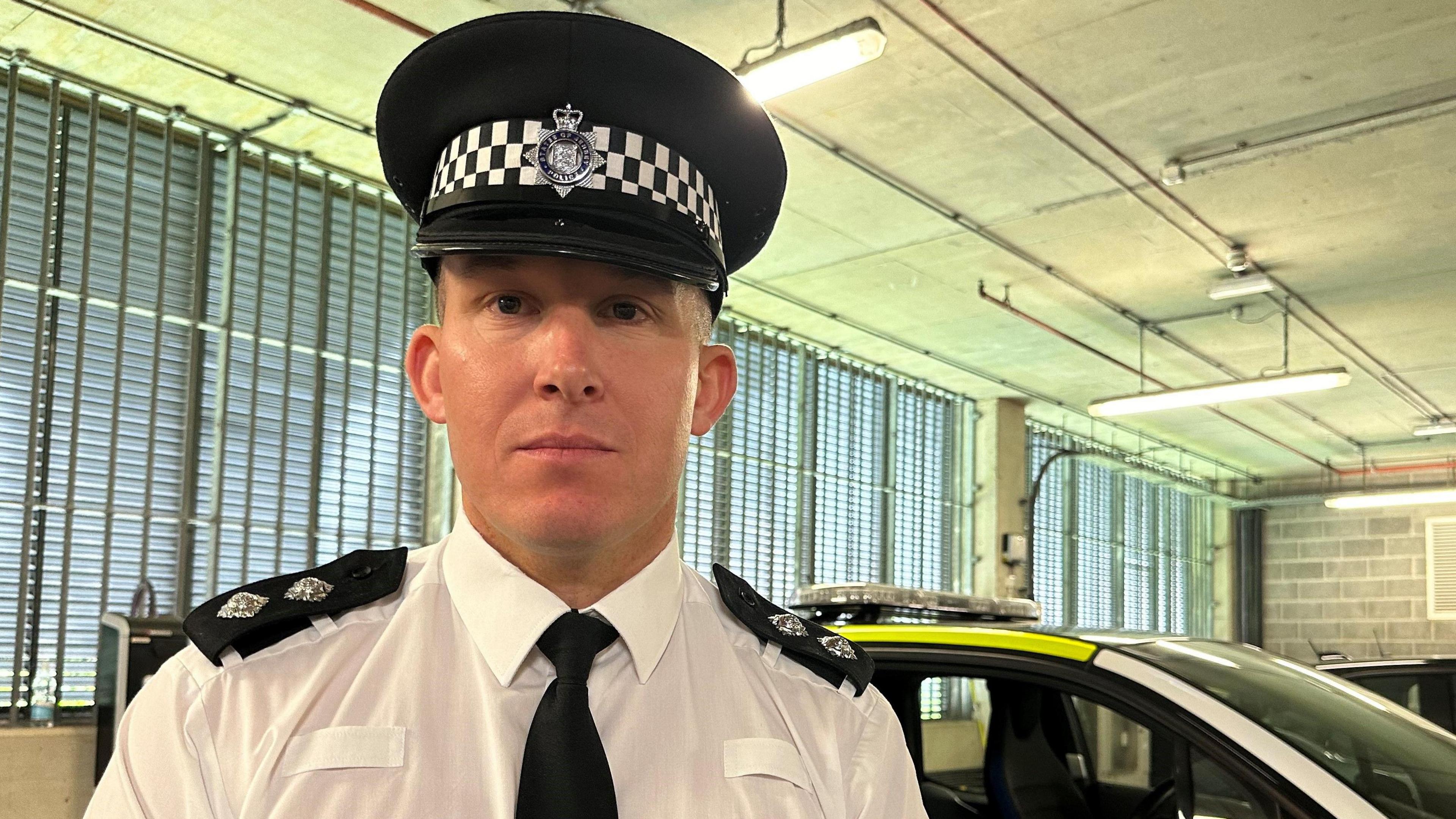 Police officer in front of police vehicle