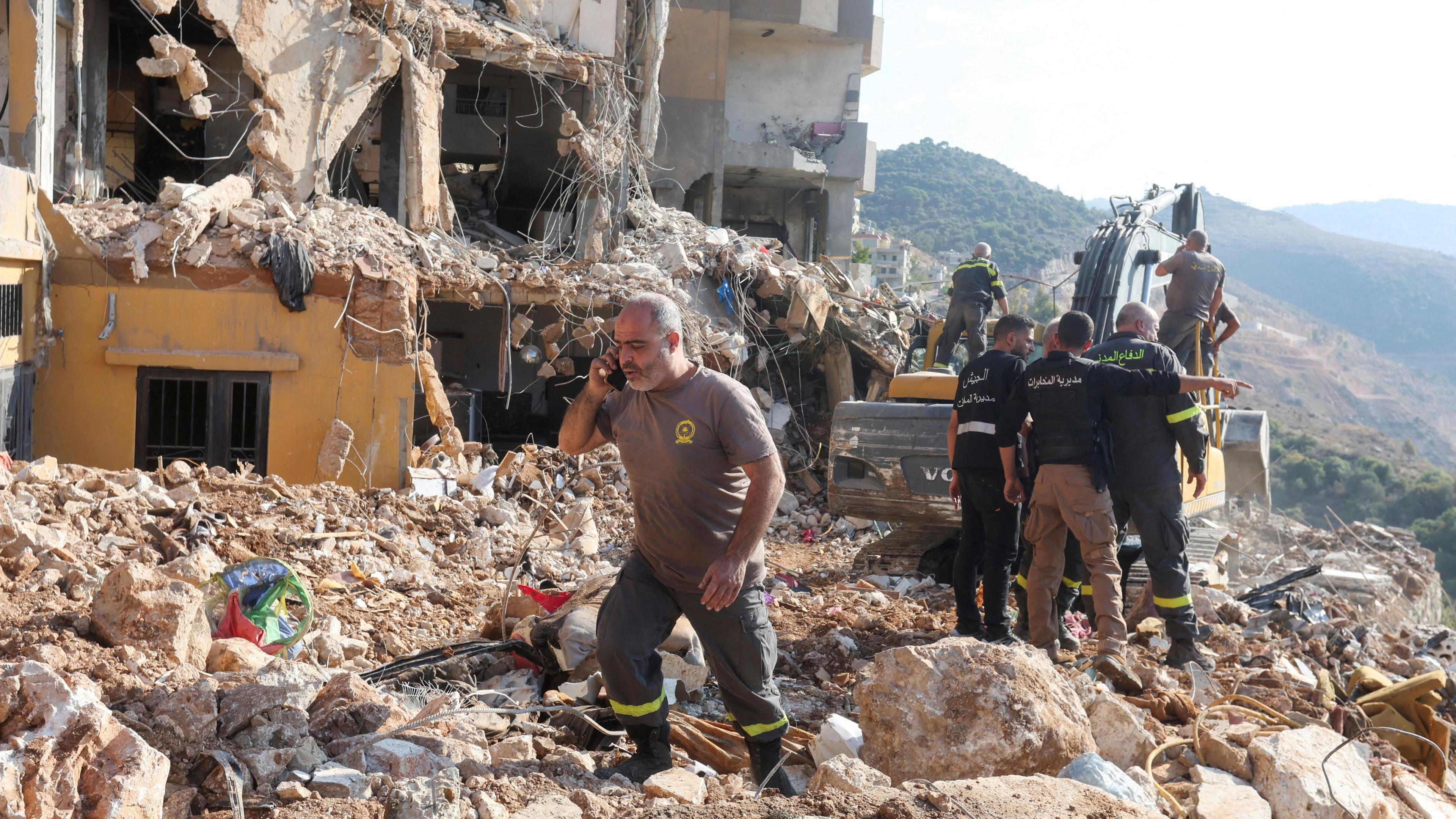 Lebanese Civil Defence first responders search through rubble after a deadly Israeli strike on an apartment building in Barja, central Lebanon (6 November 2024)