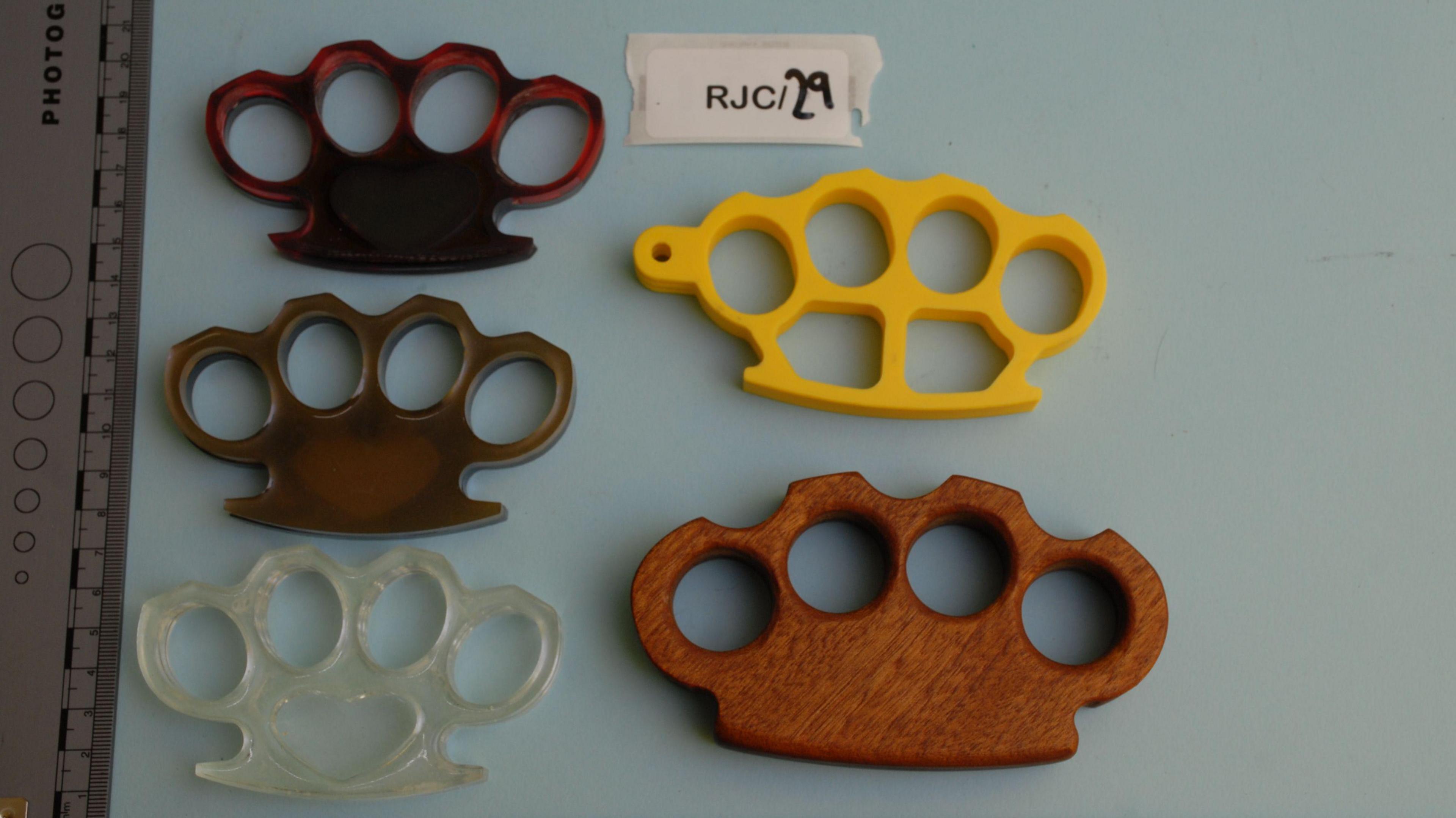 Five brown, yellow and clear knuckle-dusters