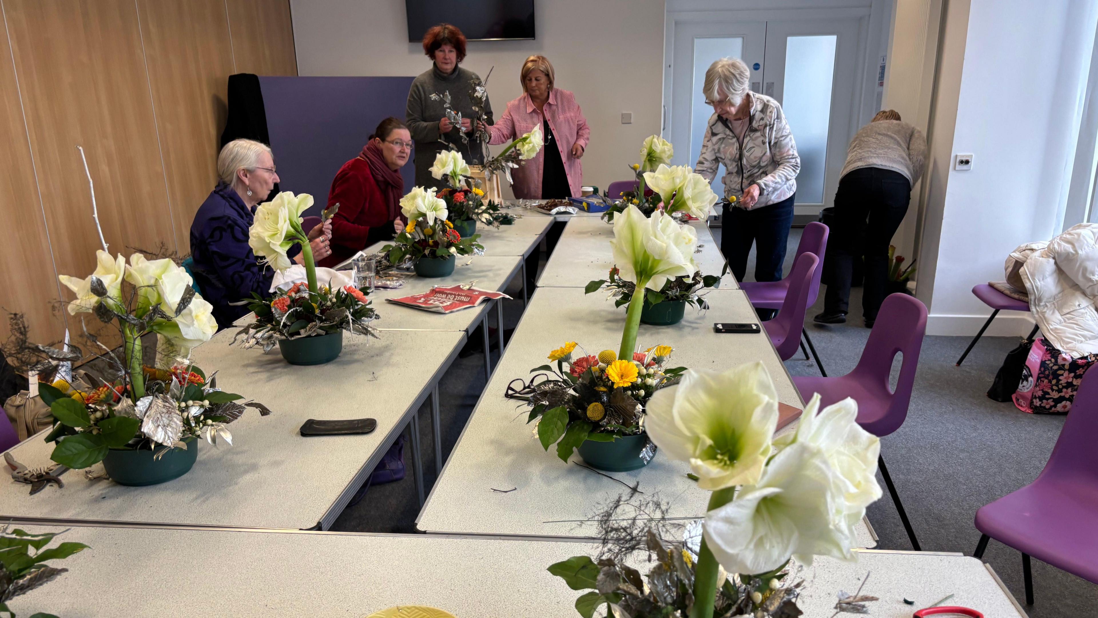 Flower arrangement class at the community centre with flowers on the tables. 