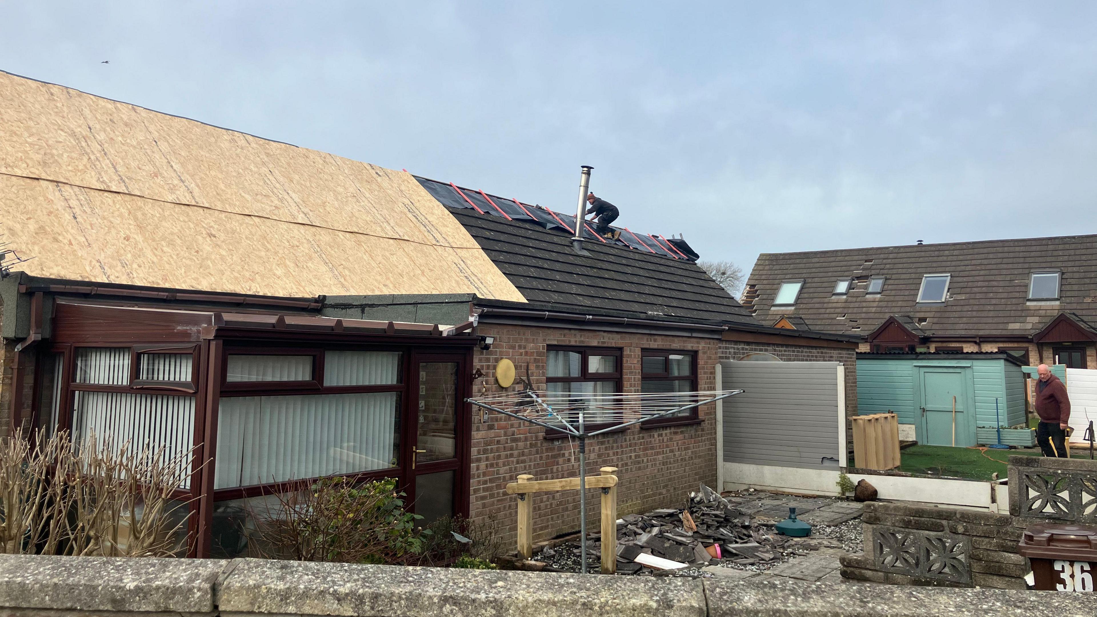 A house with wooden panels covering damaged roofs