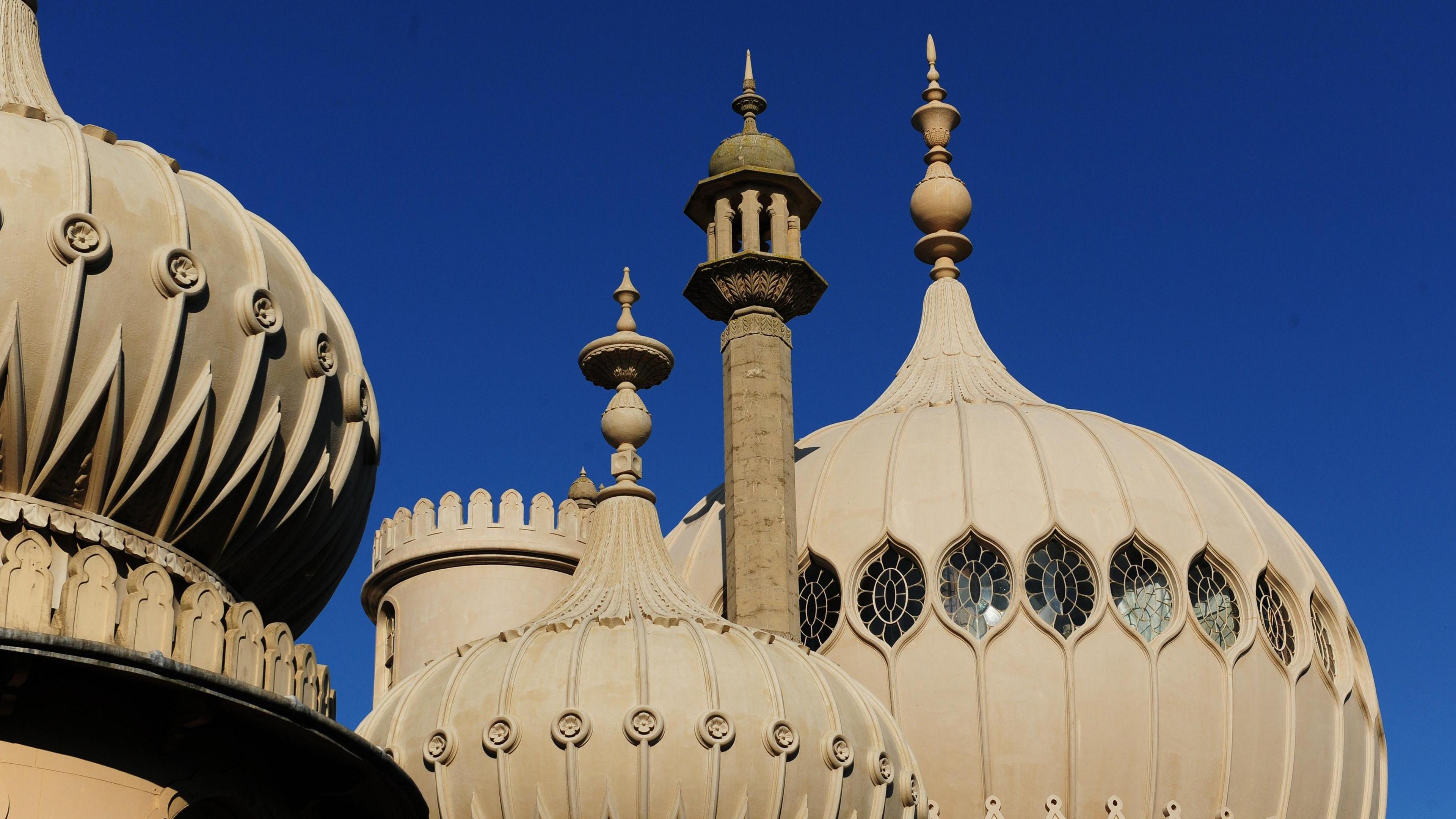 The towers of Brighton Pavilion highlighted against a deep blue sky.