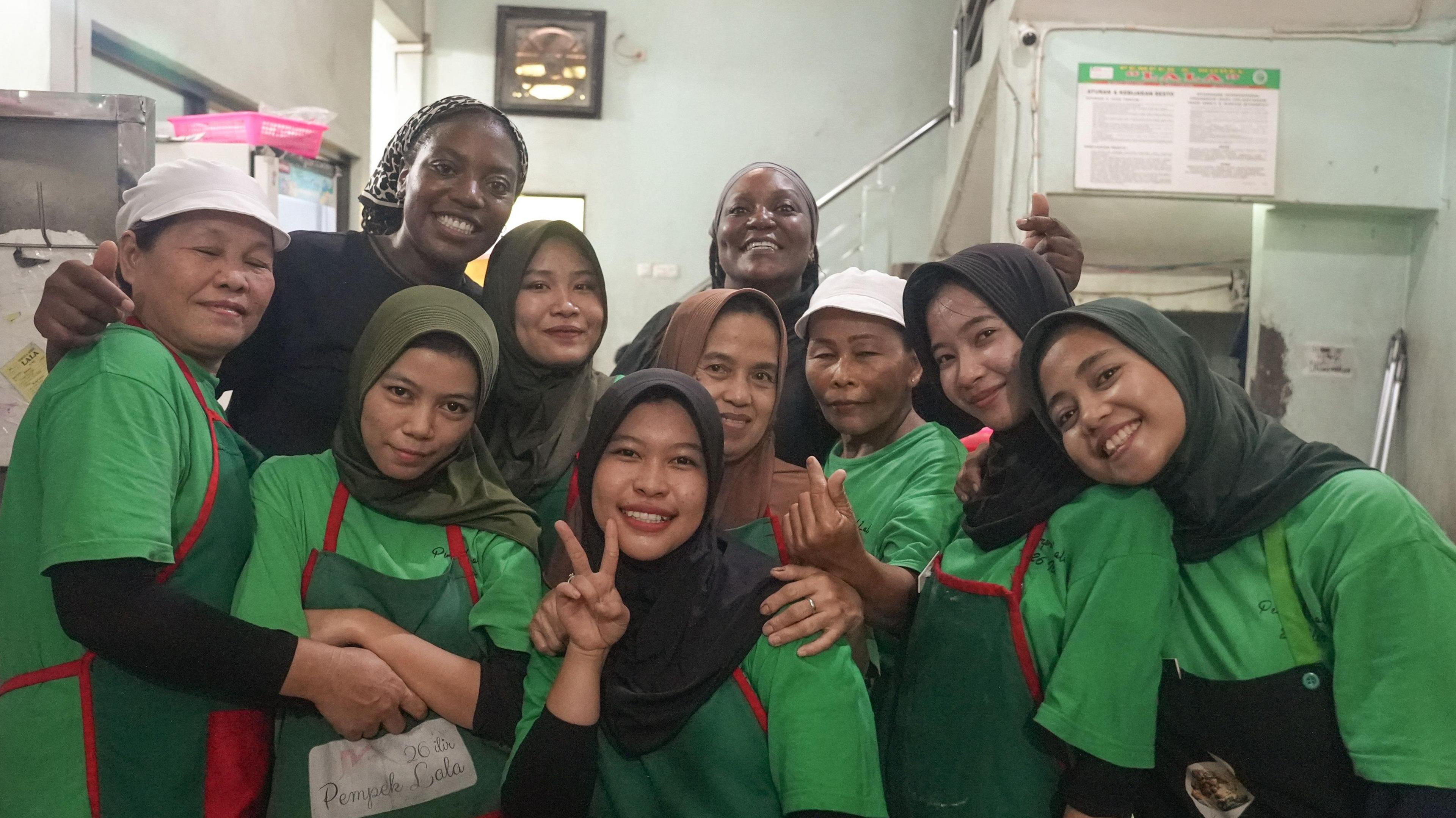 Isabel and Eugenie posing with fellow workers while they earn travel money money