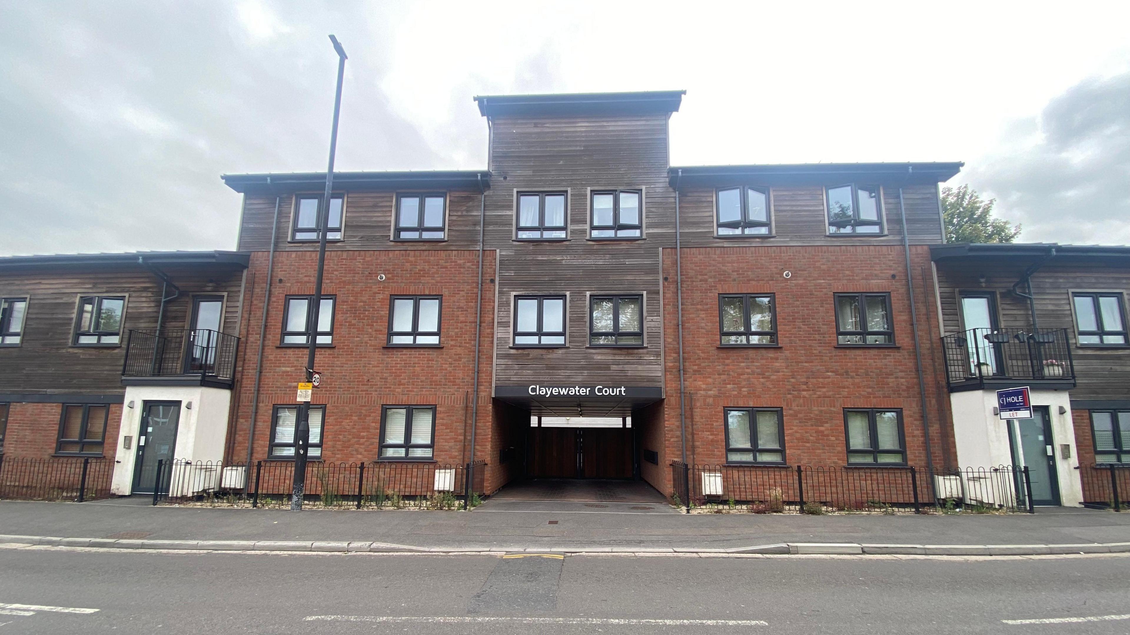 External shot of Clayewater Court, which is three storeys high and has cladding on its top half